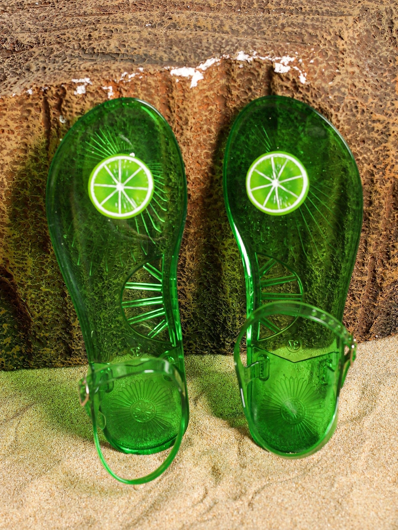 Green women’s clear jelly flat slide sandals with fruit graphic decoration and toe post design, suitable for beach, vacation, and casual outdoor wear.