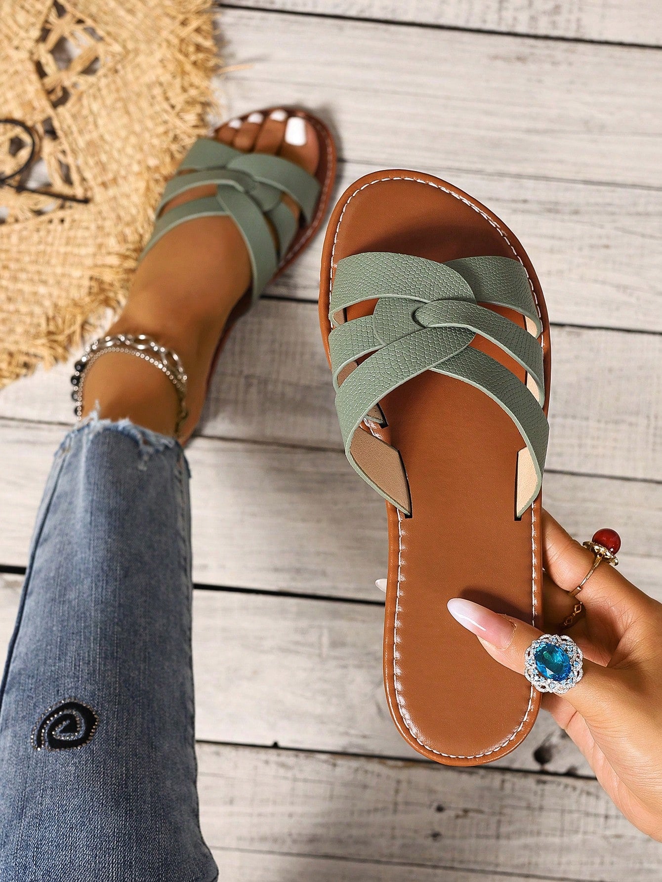 Women’s flat open-toe slide sandals with braided strap detail, embossed texture, and rhinestone decoration, designed as casual slip-on footwear for beach and everyday outdoor wear.