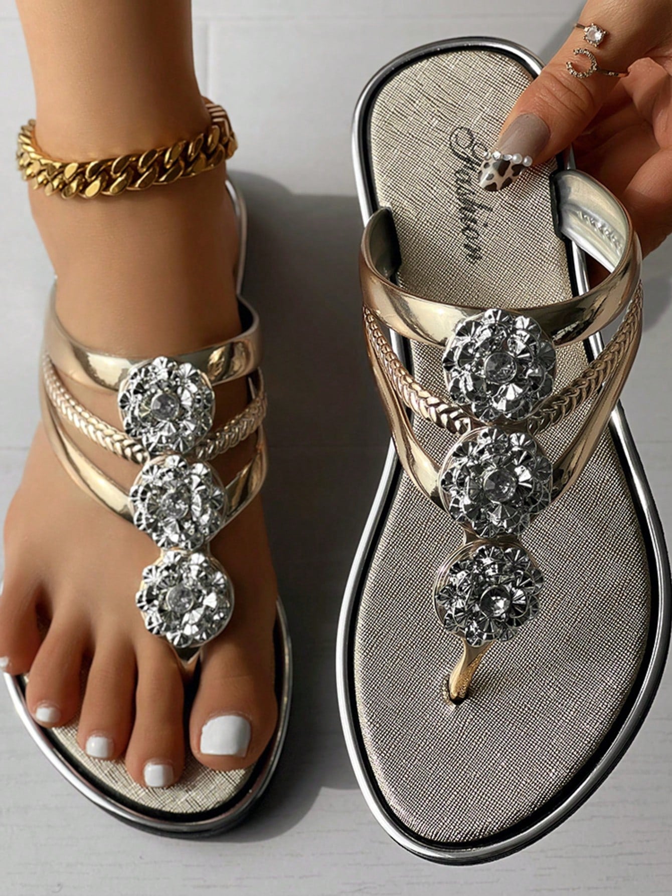 Women's gold metal-look open-toe strappy slide sandals with crystal floral rhinestone decor and flat sole, suitable for beach, vacation, and casual wear.