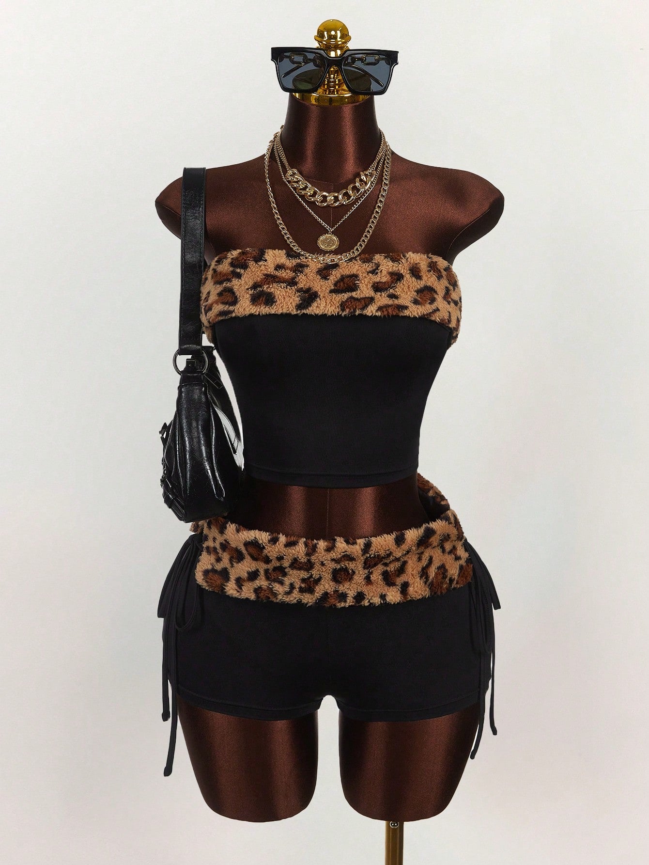Women's black leopard print two-piece set with strapless bandeau crop top, knot and lace-up details, and matching mini shorts.