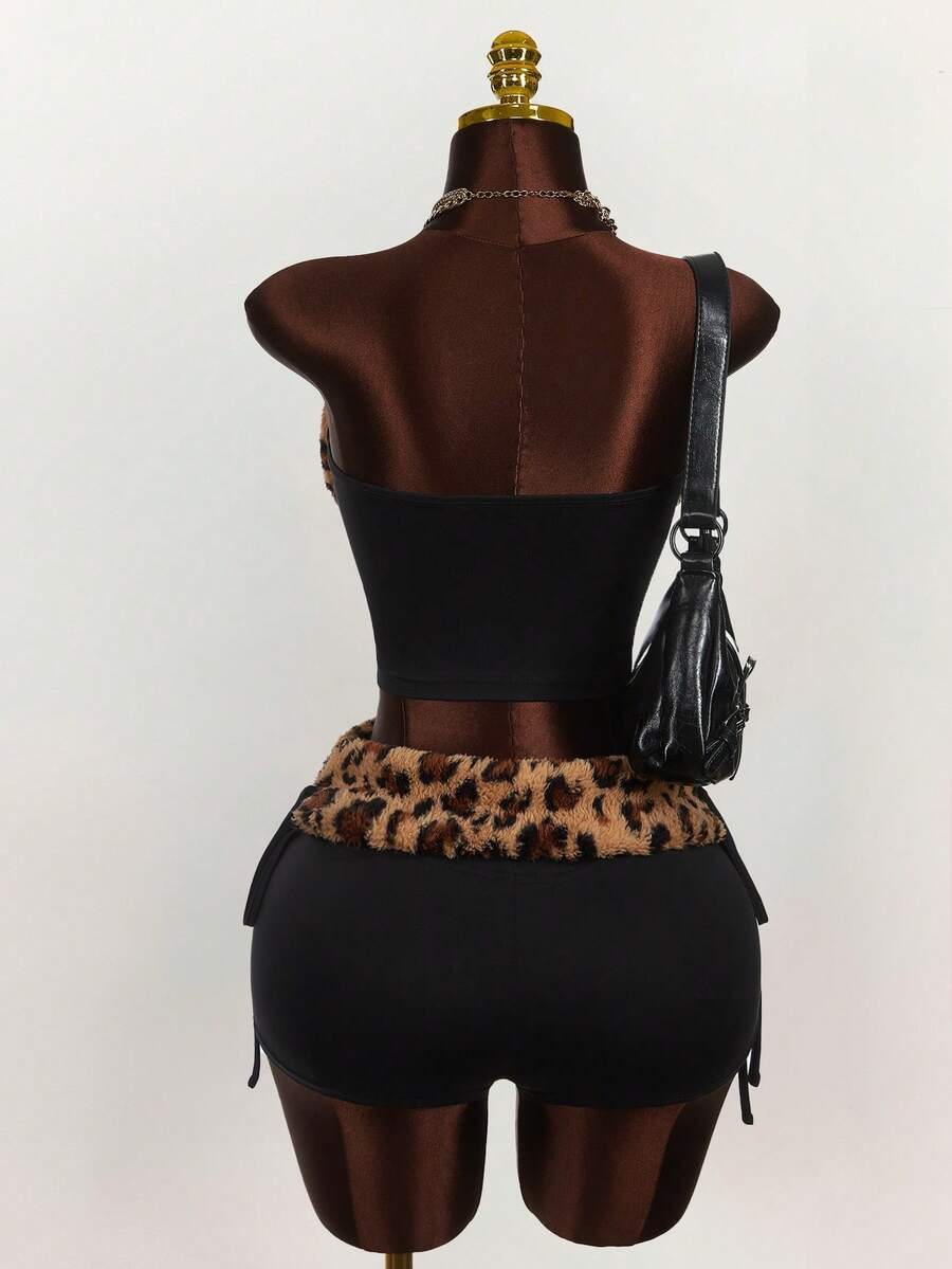 Women's black leopard print two-piece set with strapless bandeau crop top, knot and lace-up details, and matching mini shorts.