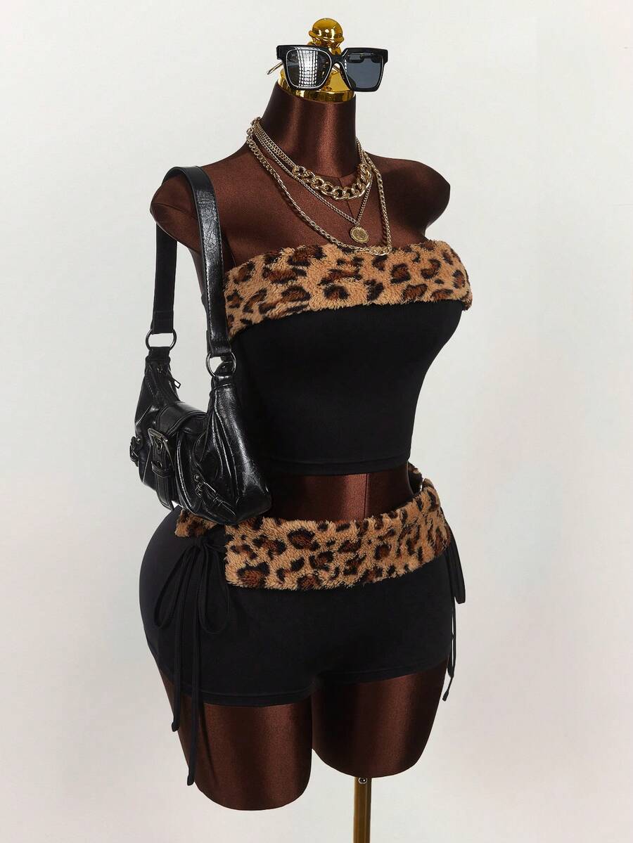 Women's black leopard print two-piece set with strapless bandeau crop top, knot and lace-up details, and matching mini shorts.