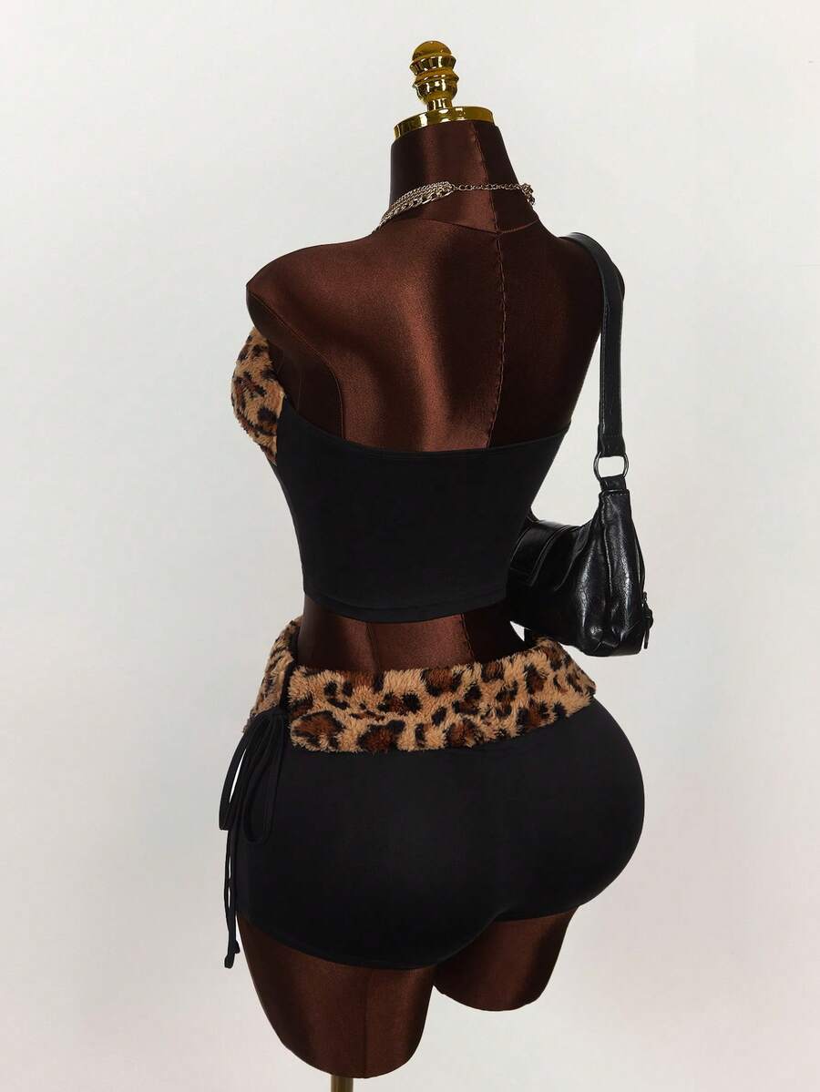 Women's black leopard print two-piece set with strapless bandeau crop top, knot and lace-up details, and matching mini shorts.