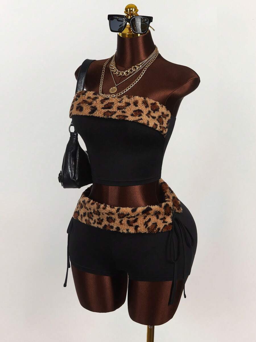 Women's black leopard print two-piece set with strapless bandeau crop top, knot and lace-up details, and matching mini shorts.