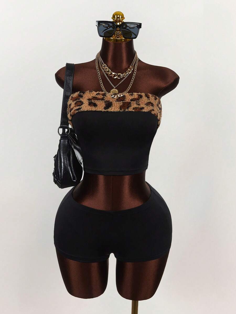 Women's black leopard print two-piece set with strapless bandeau crop top, knot and lace-up details, and matching mini shorts.