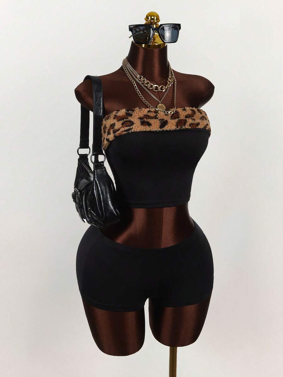Women's black leopard print two-piece set with strapless bandeau crop top, knot and lace-up details, and matching mini shorts.