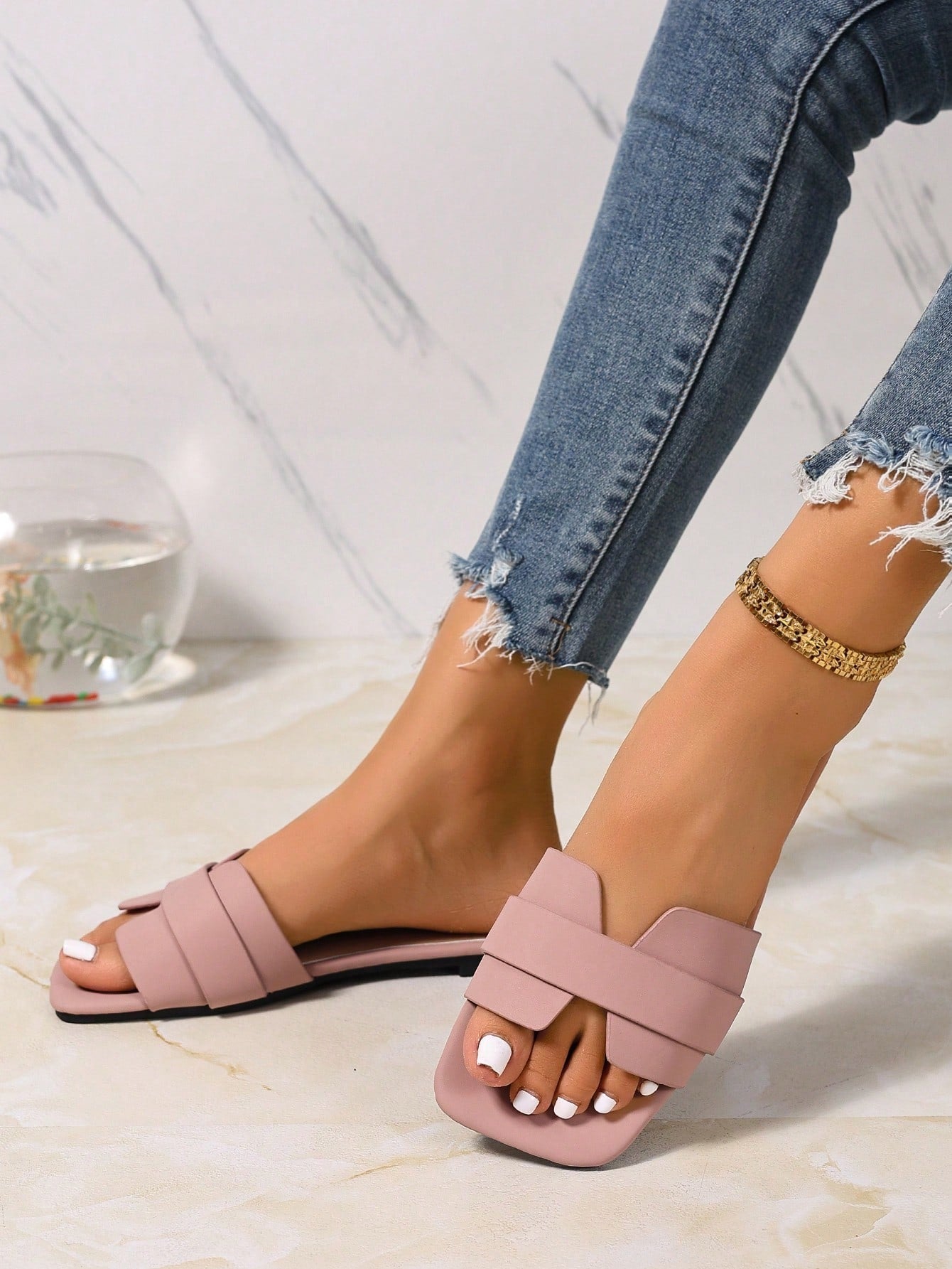 Women’s flat open-toe slide sandals with braided strap detail, embossed texture, and rhinestone decoration, designed as casual slip-on footwear for beach and everyday outdoor wear.