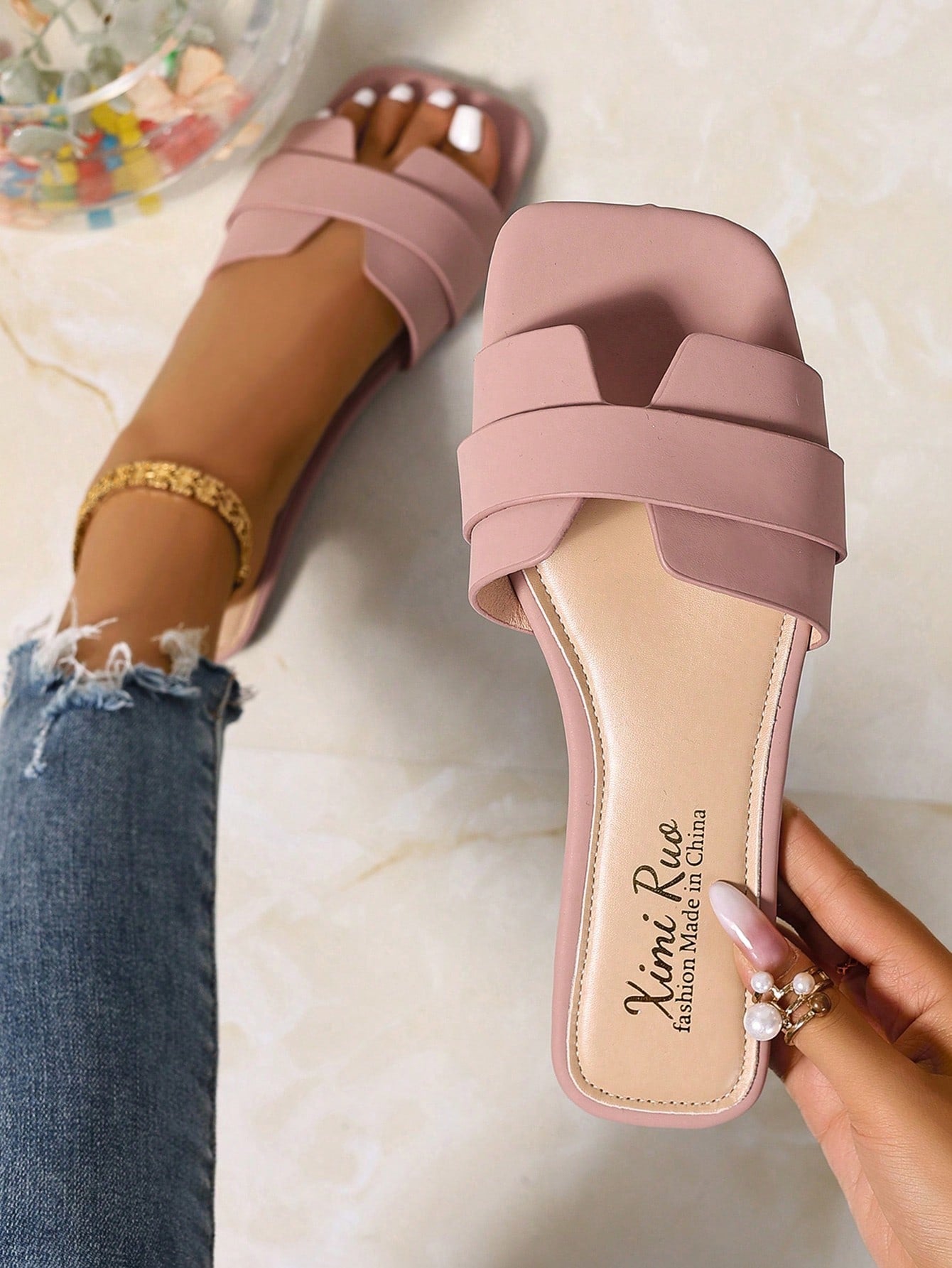 Women’s flat open-toe slide sandals with braided strap detail, embossed texture, and rhinestone decoration, designed as casual slip-on footwear for beach and everyday outdoor wear.