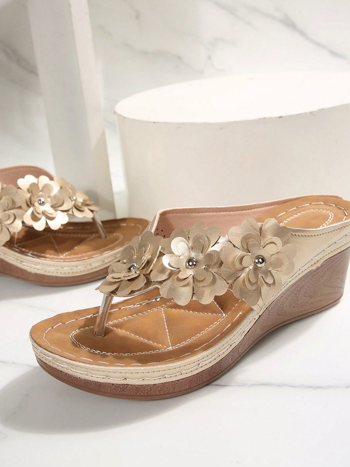 Women's gold platform flip flop wedge sandals with toe post and textured flower detail, slip-on vacation slide style with mid heel.
