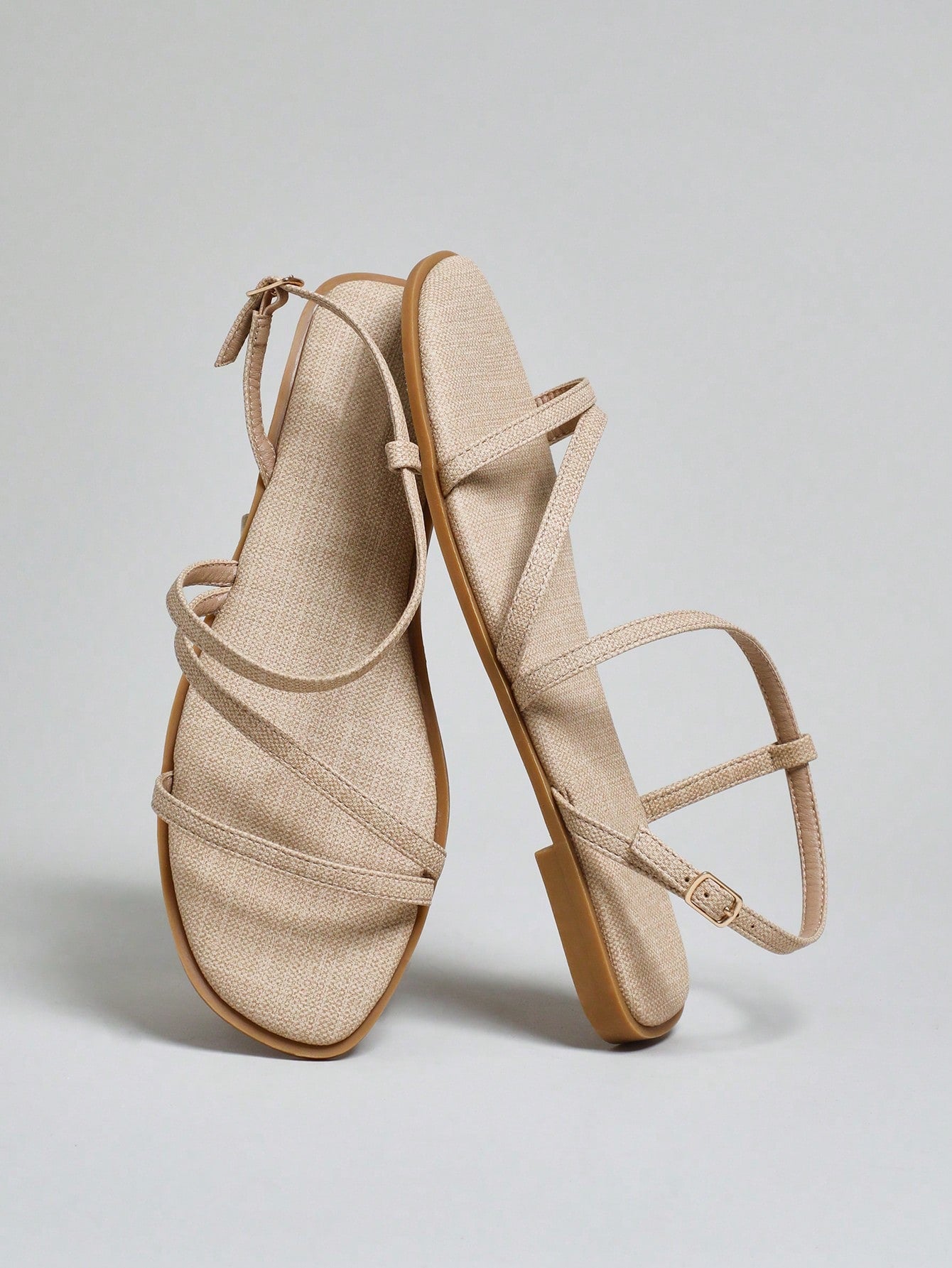 Women's flat open-toe sandals featuring a buckle detail and PU leather construction with a flat sole.
