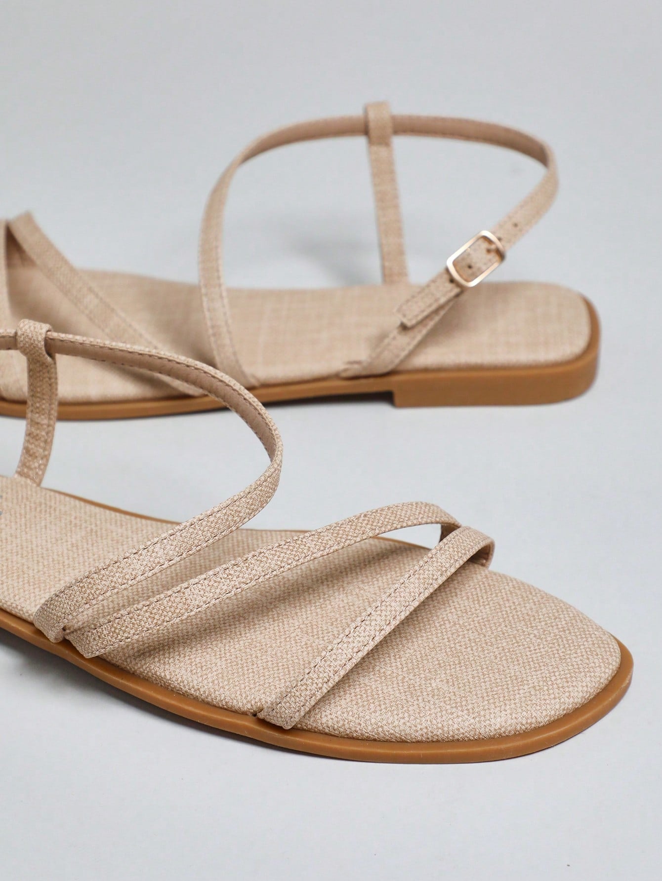 Women's flat open-toe sandals featuring a buckle detail and PU leather construction with a flat sole.