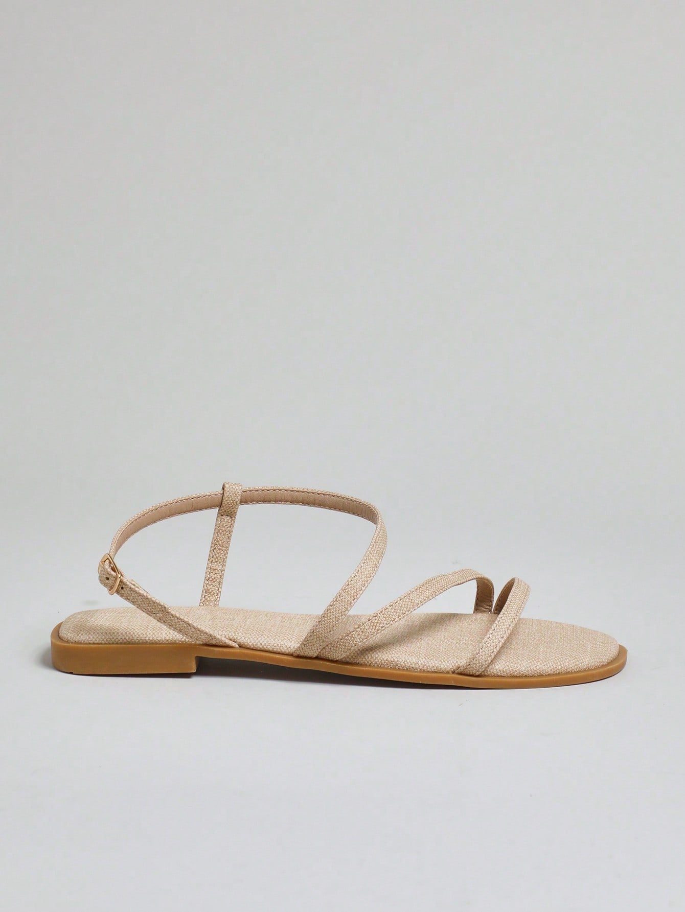 Women's flat open-toe sandals featuring a buckle detail and PU leather construction with a flat sole.