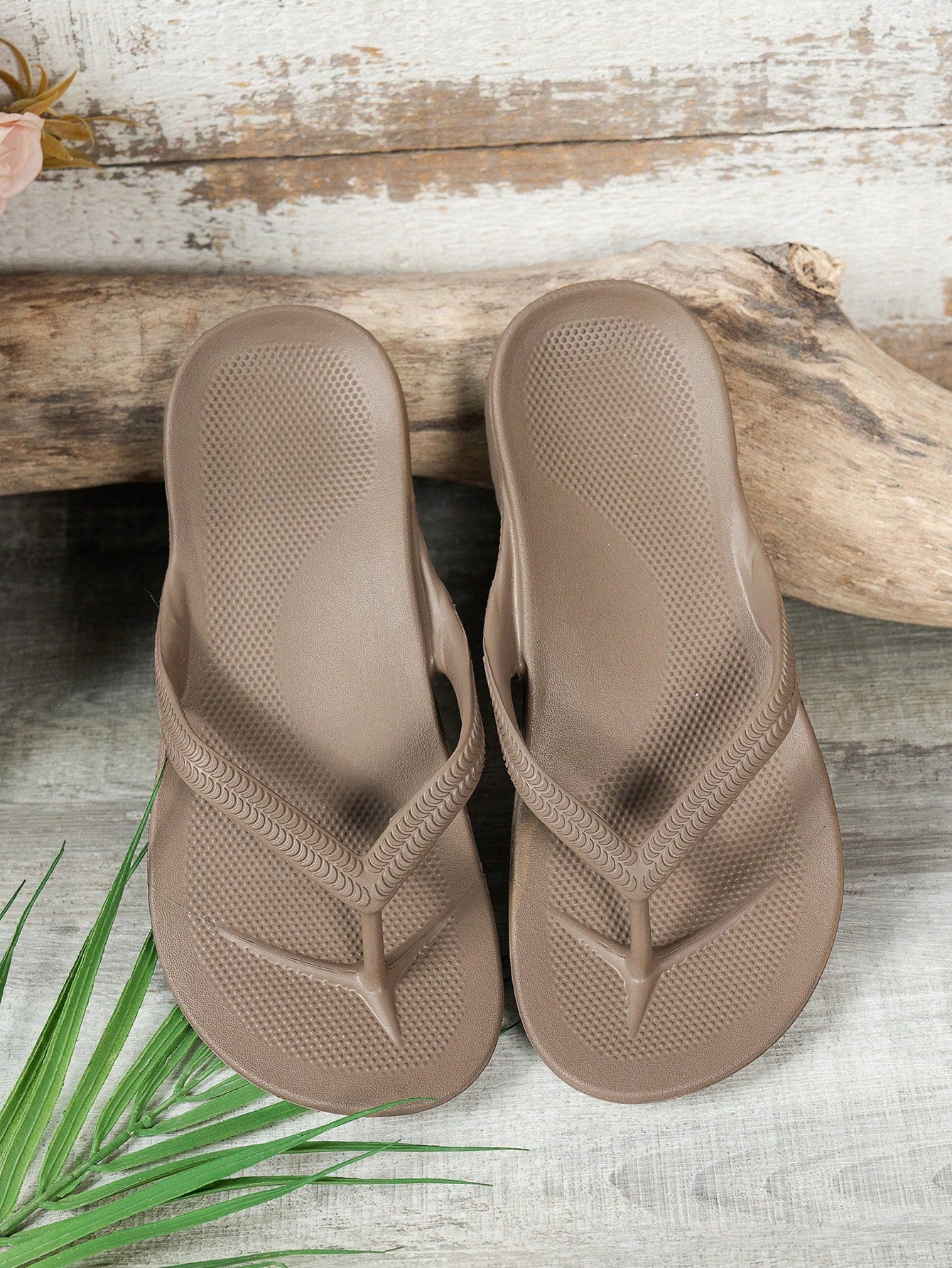 Women's solid color flip flops with open-toe design, flat sole, and cut-out details, suitable for casual indoor or outdoor wear at the beach or pool.
