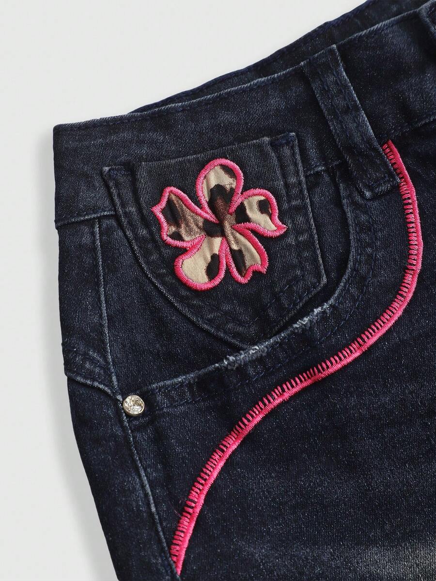 Blue Y2K low waist shorts with butterfly embroidery, distressed washed finish, raw hem, button detail, and zipper fly closure.