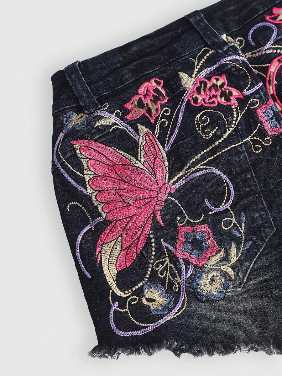Blue Y2K low waist shorts with butterfly embroidery, distressed washed finish, raw hem, button detail, and zipper fly closure.