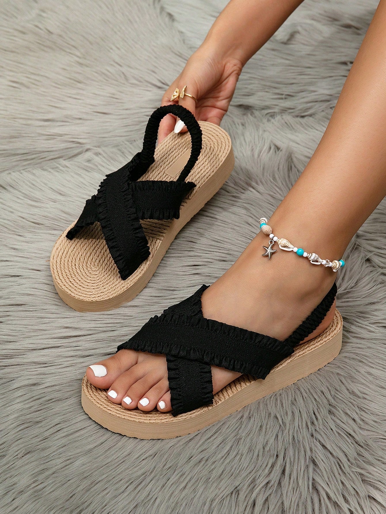 Women's open toe slip-on wedge sandals with criss cross straps and folk-custom styling, featuring raw hem, fringe, tassel, braid, and tape details.