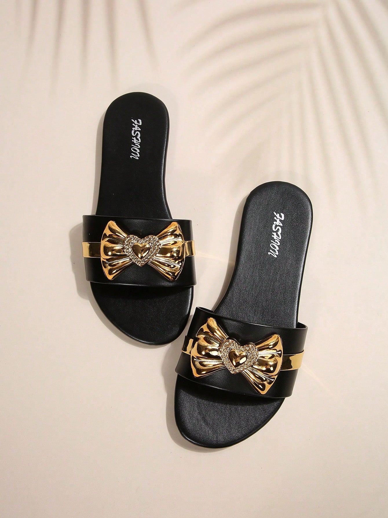 Pair of women's black flat slide sandals featuring rhinestone embellishments, metal accents, and a gold-strip detail on the upper, with an open-toe slip-on design.