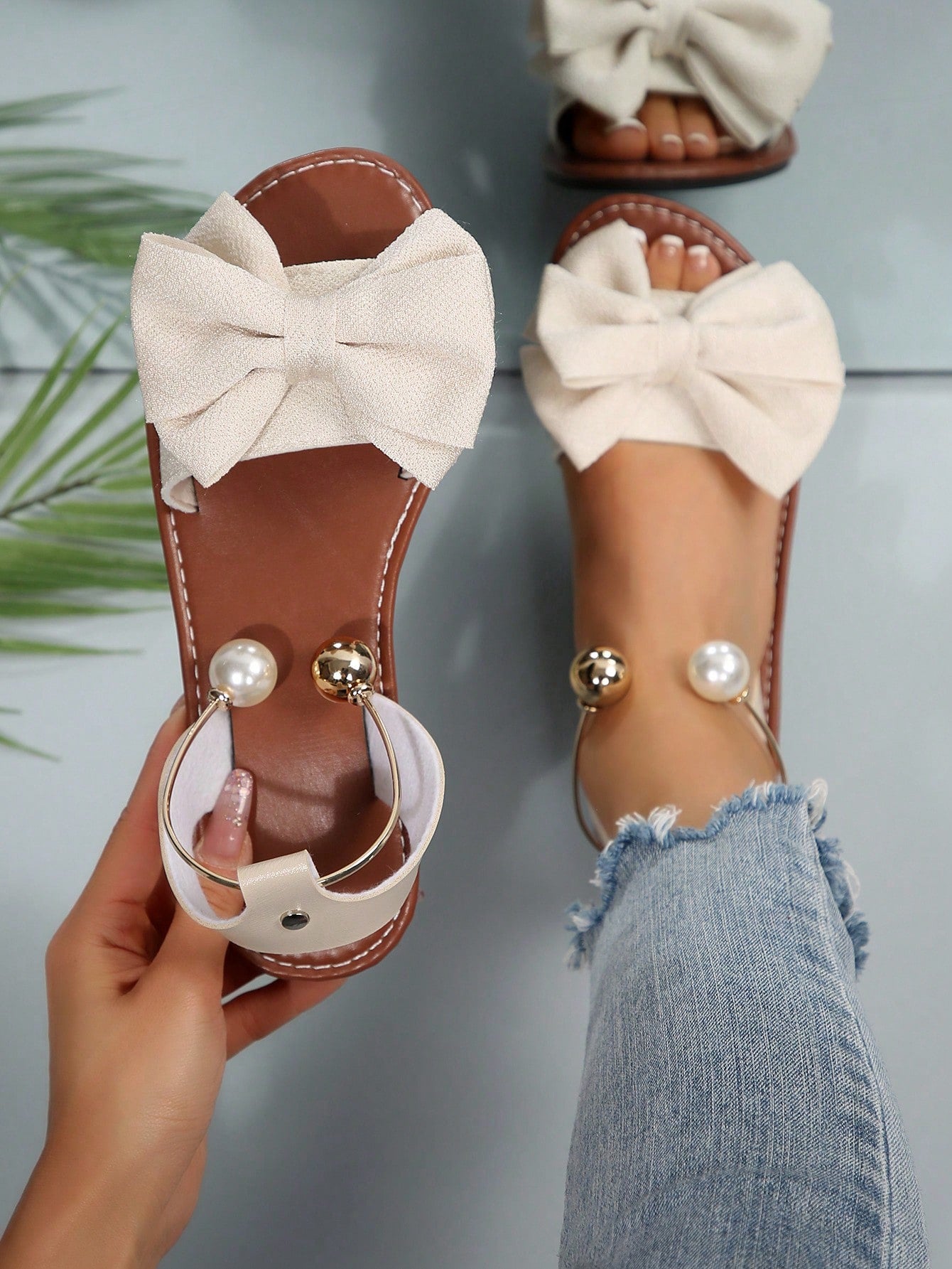 Women’s flat open-toe sandals with faux pearl decor and ankle strap design, featuring a microfiber leather upper and beach-ready fashion style.