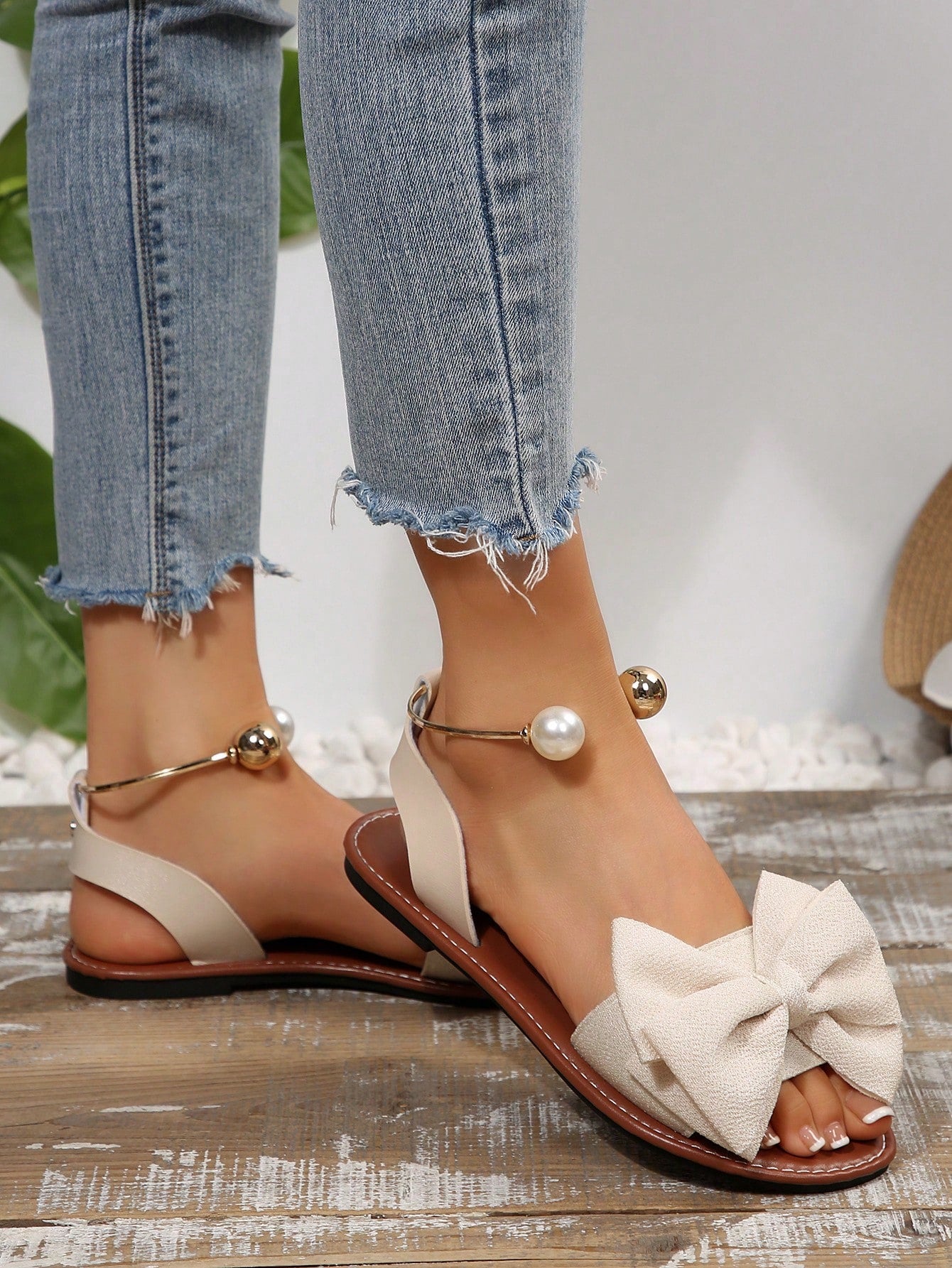 Women’s flat open-toe sandals with faux pearl decor and ankle strap design, featuring a microfiber leather upper and beach-ready fashion style.
