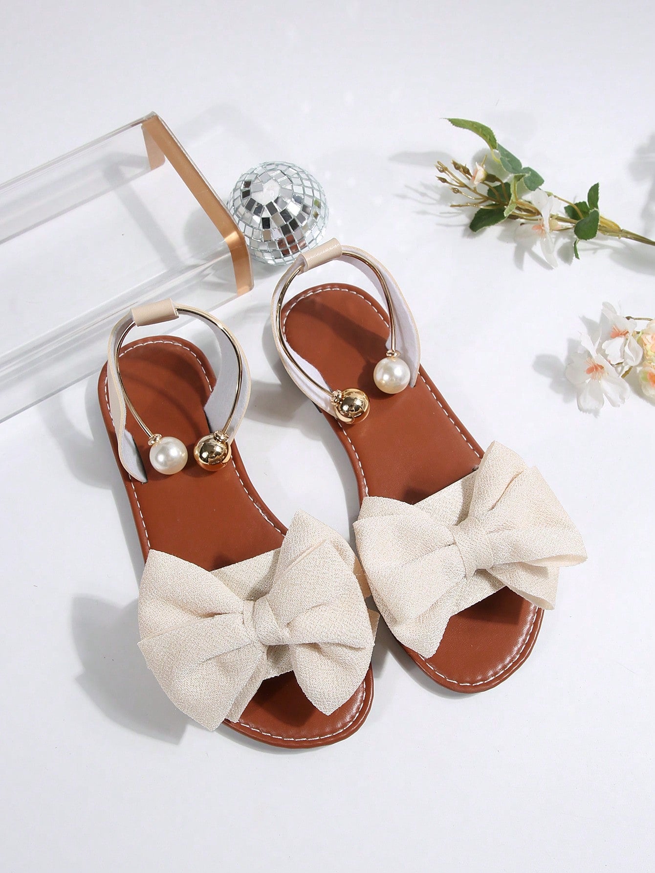 Women’s flat open-toe sandals with faux pearl decor and ankle strap design, featuring a microfiber leather upper and beach-ready fashion style.