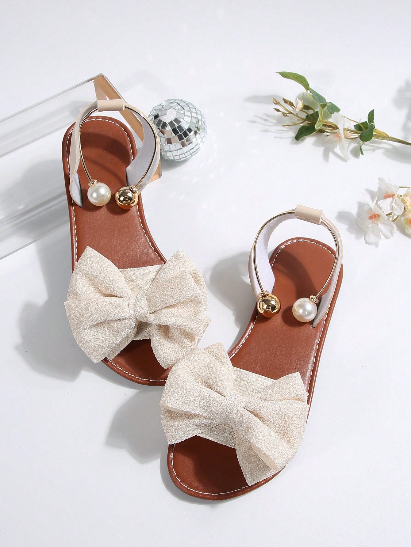 Women’s flat open-toe sandals with faux pearl decor and ankle strap design, featuring a microfiber leather upper and beach-ready fashion style.