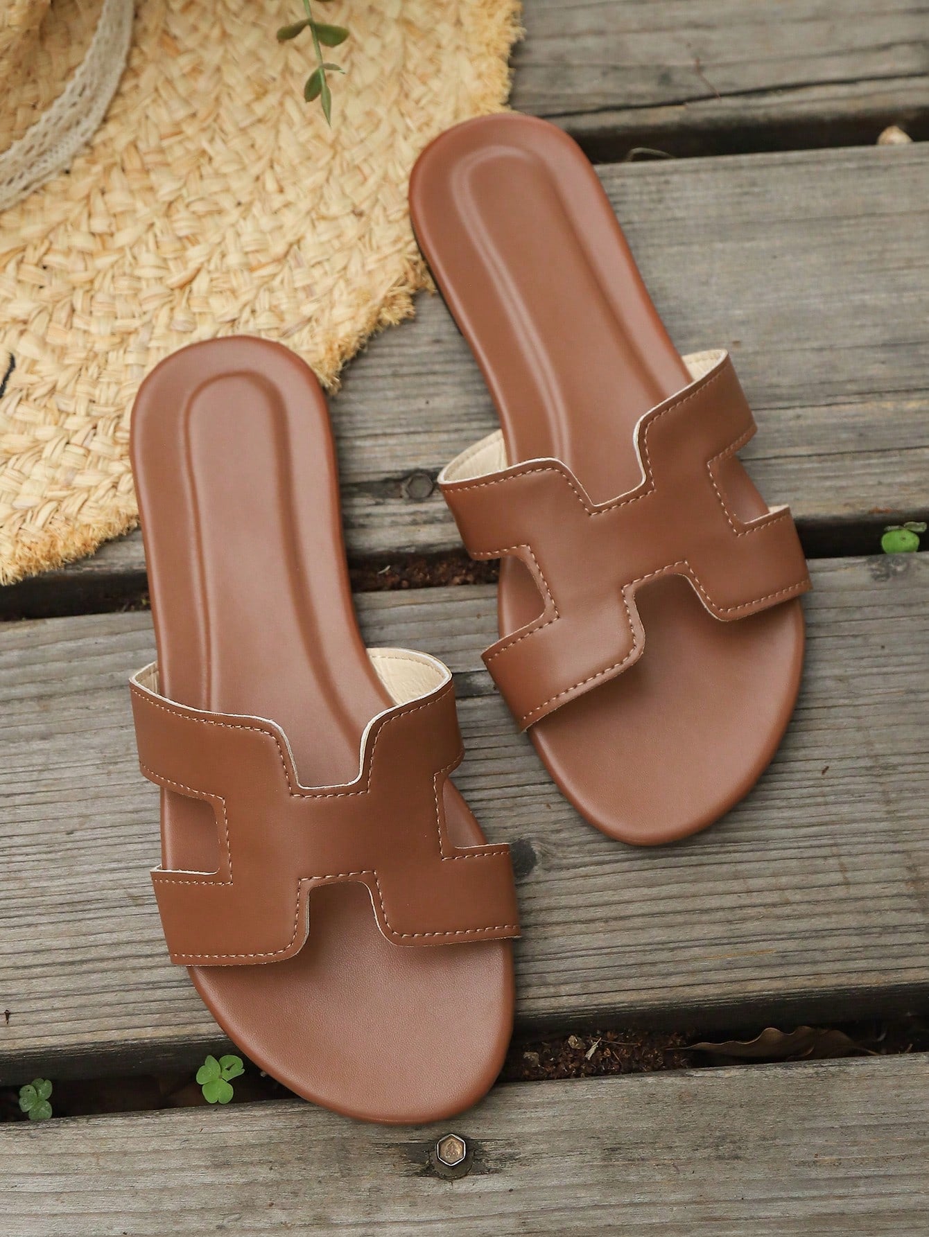 Women's flat open-toe beach sandals with criss-cross and cut-out upper design, suitable for seaside travel and casual summer wear.
