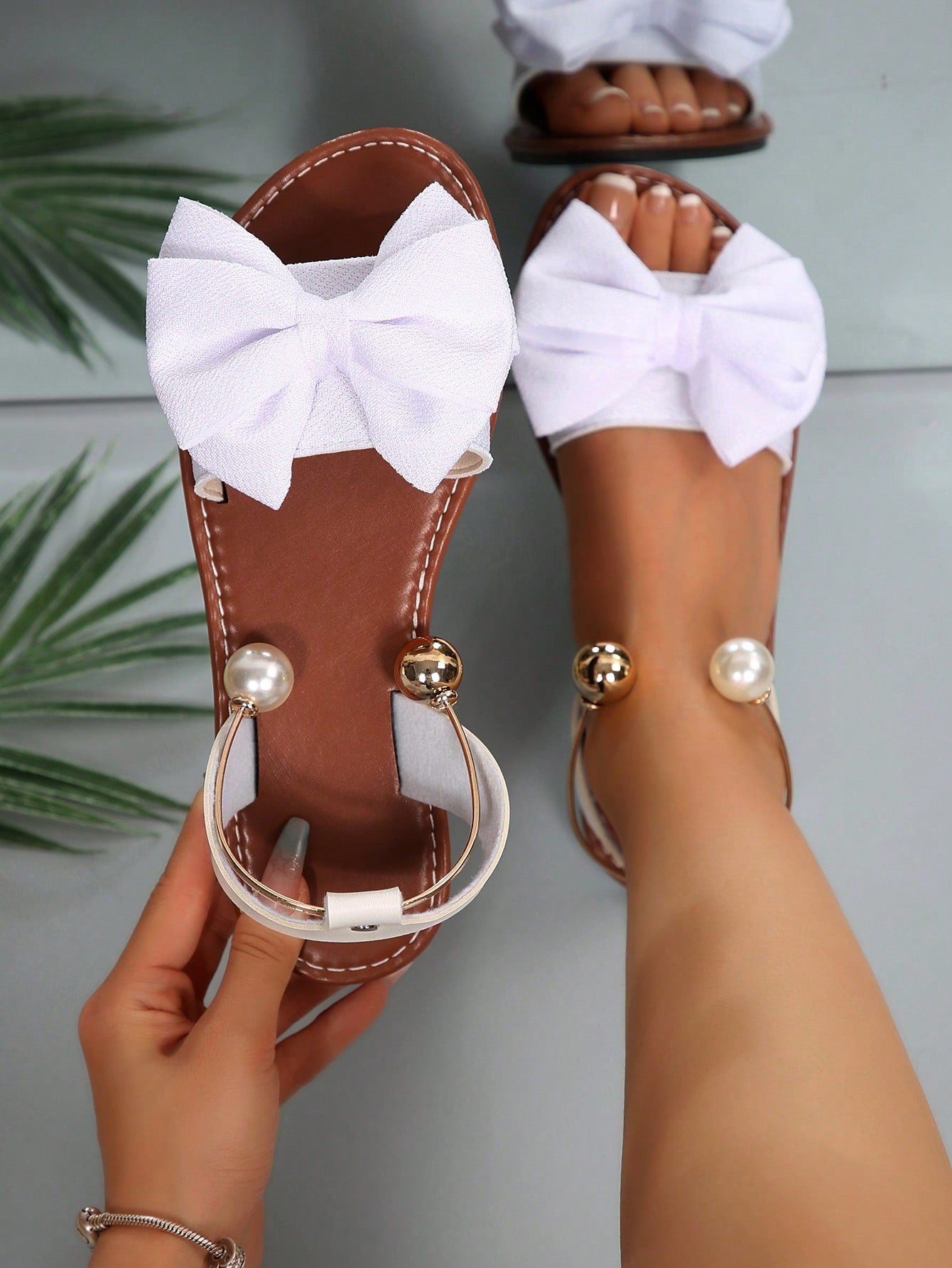 Women’s flat open-toe sandals with faux pearl decor and ankle strap design, featuring a microfiber leather upper and beach-ready fashion style.