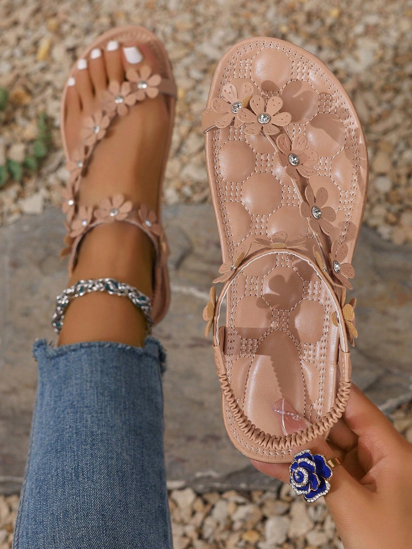Women's white flat beach thong sandals with toe-post design, featuring flower applique and rhinestone embellishment on the upper, casual summer slide style.