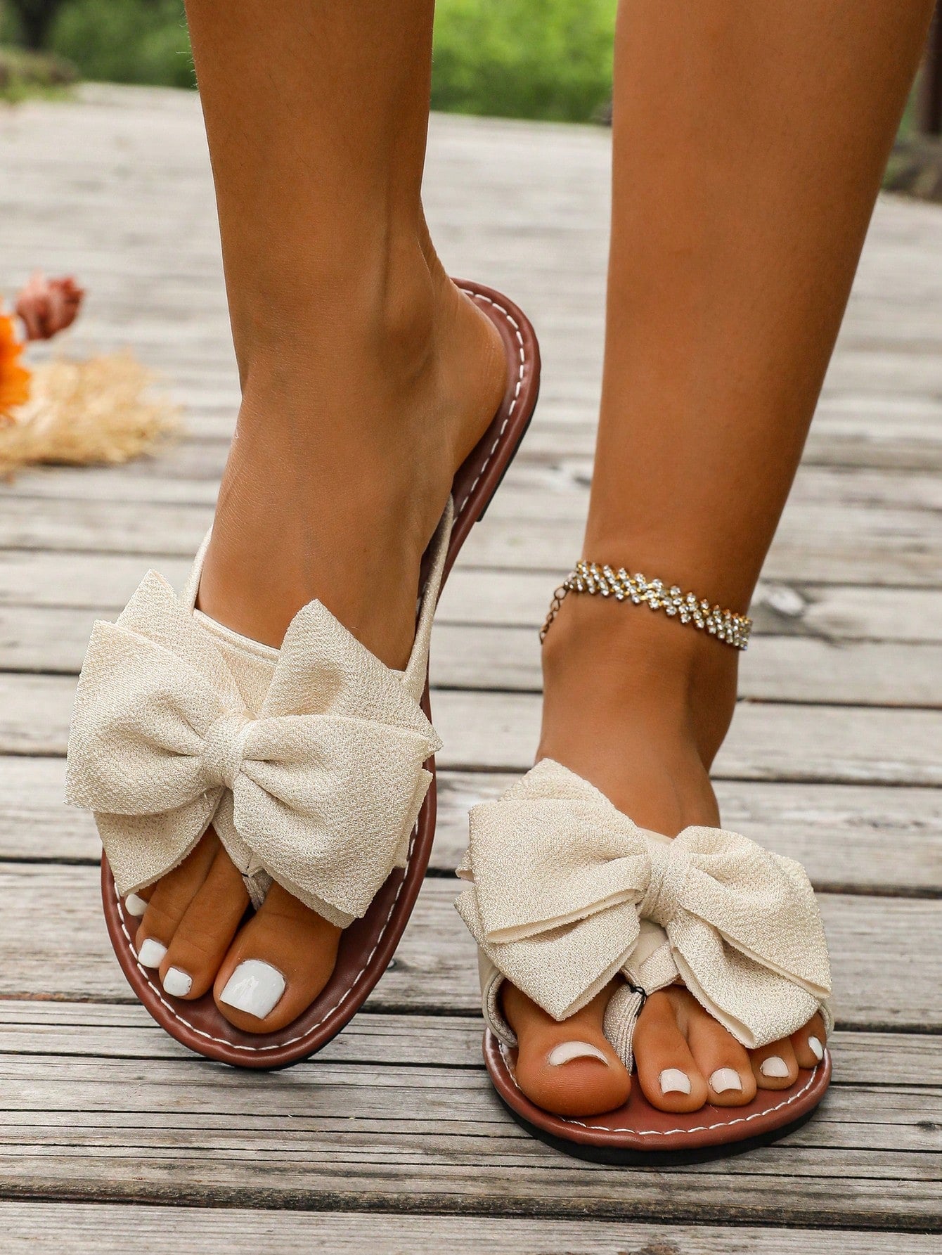 Women's flat bow thong sandals in a casual beach slide style with open toe and tropical pattern.