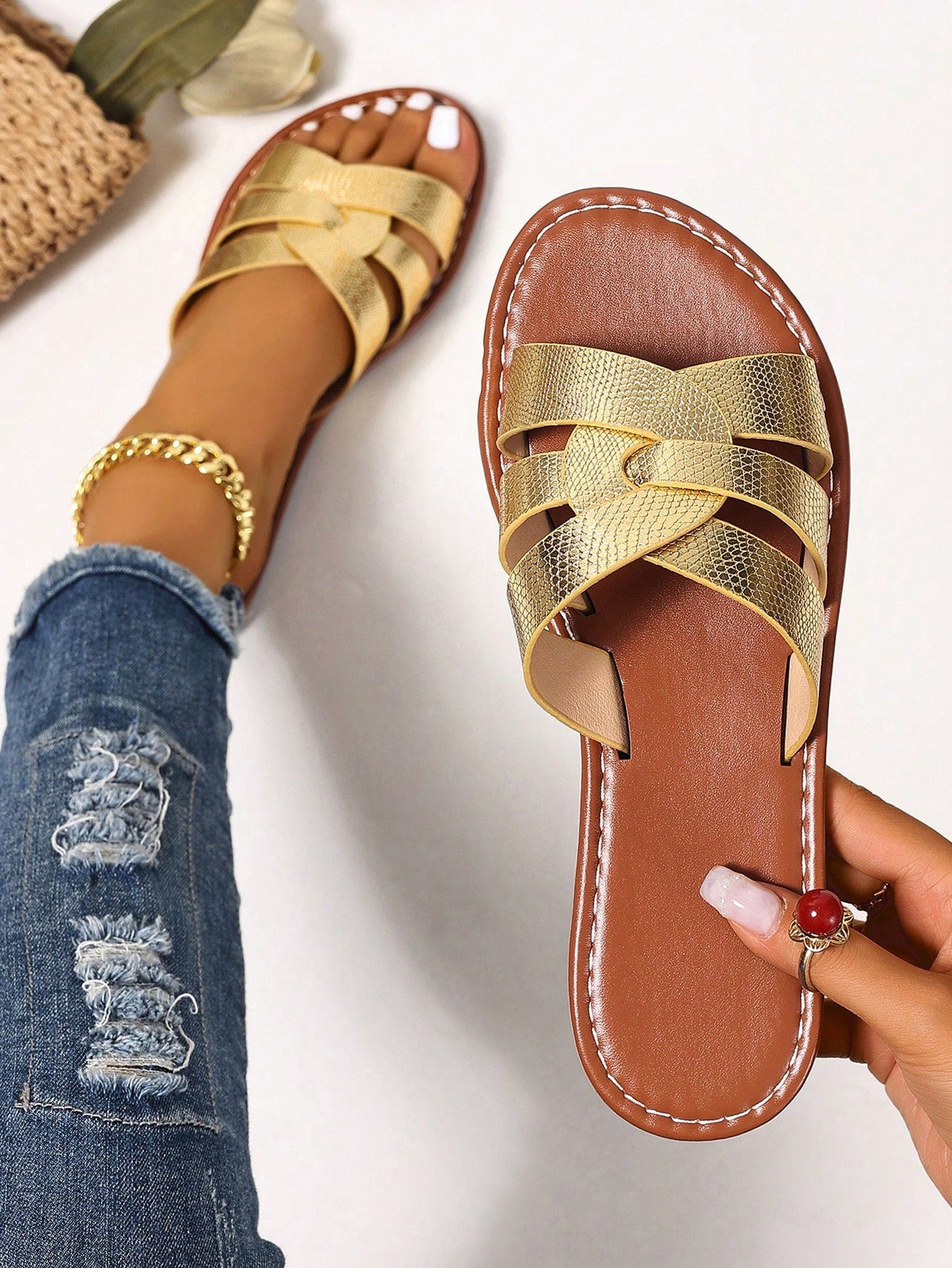 Pair of women’s open-toe flat slide sandals with an H-shaped strap, braided and embossed details, and a minimalist slip-on design suitable for casual outdoor wear.
