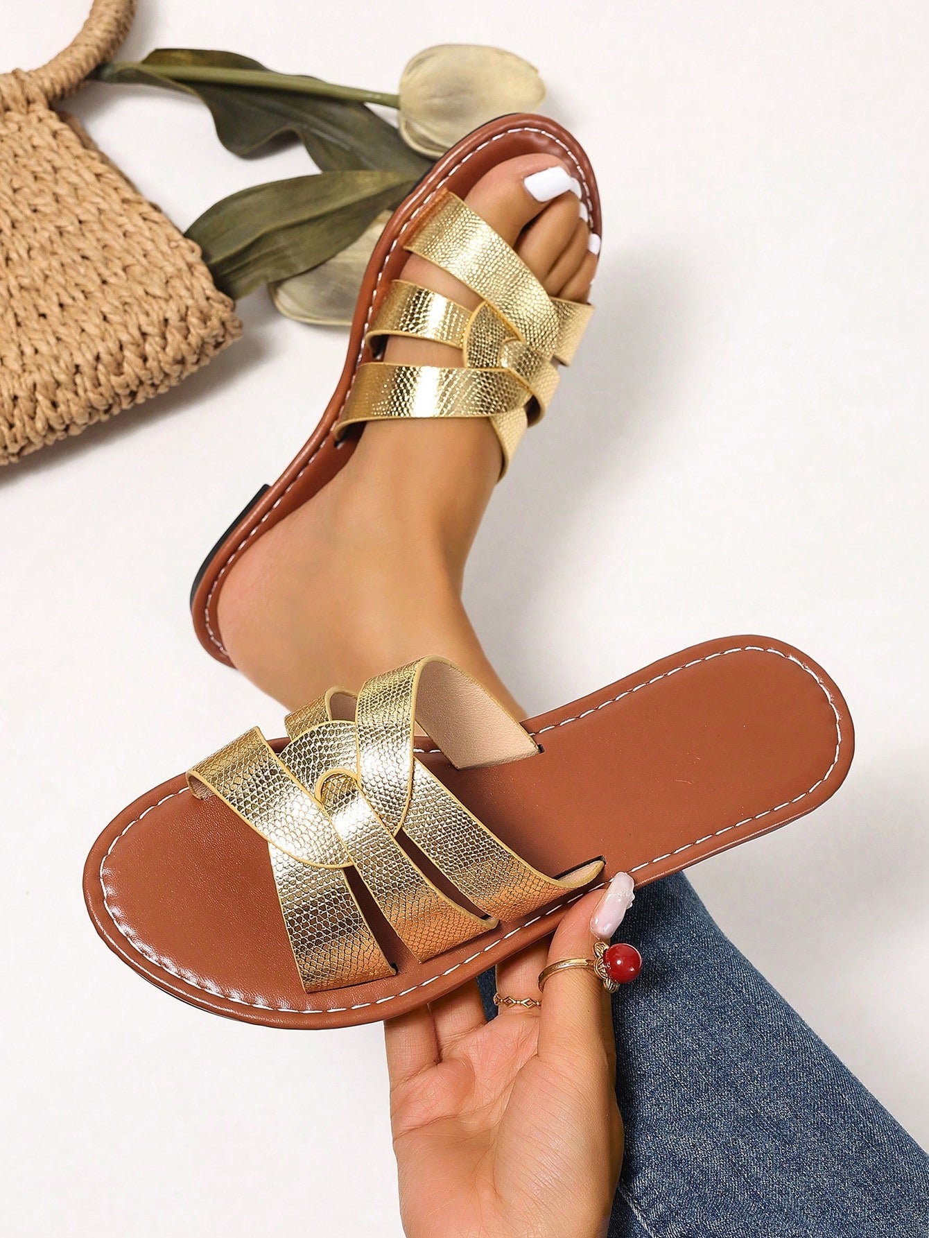 Pair of women’s open-toe flat slide sandals with an H-shaped strap, braided and embossed details, and a minimalist slip-on design suitable for casual outdoor wear.