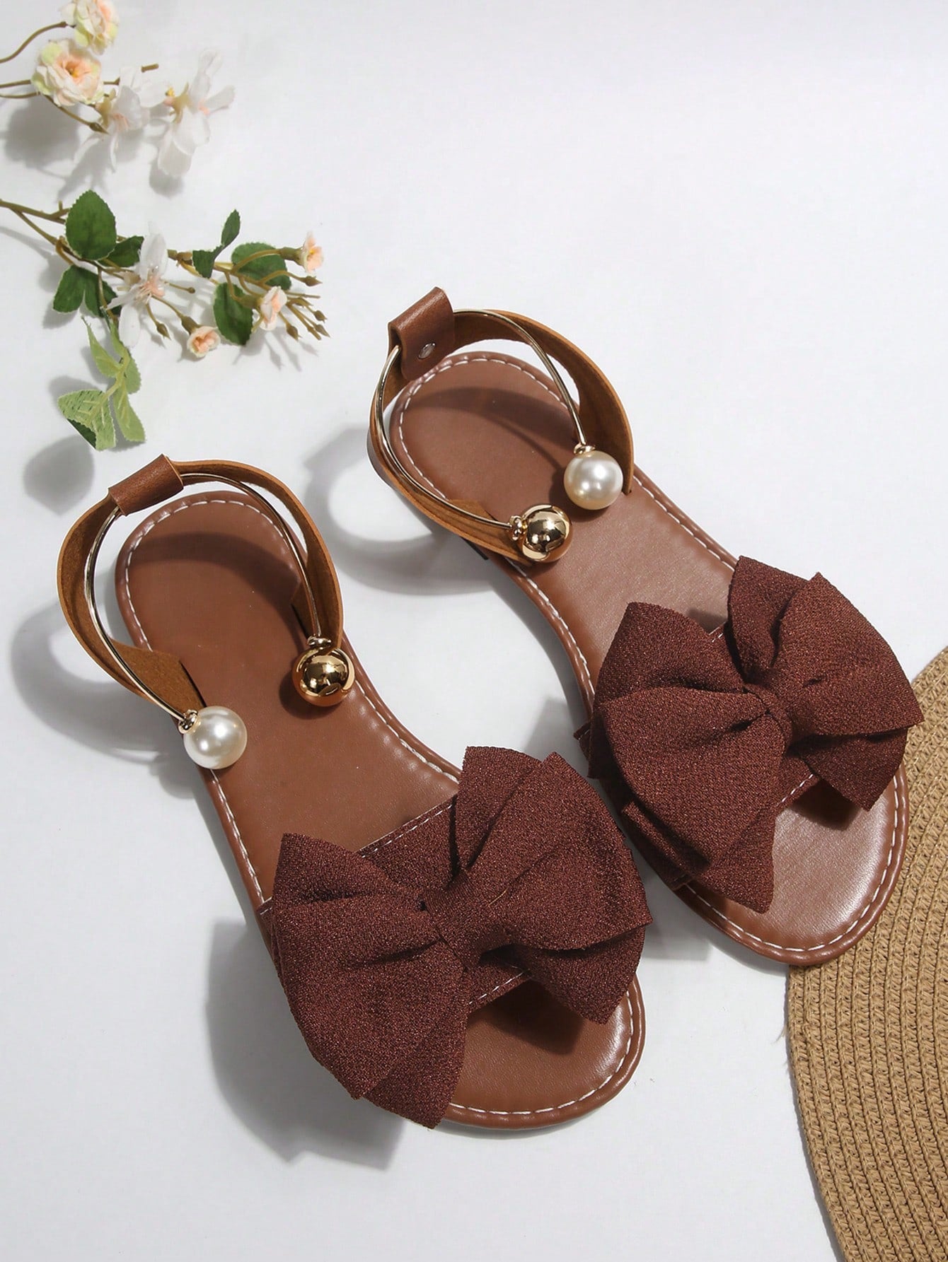 Women’s flat open-toe sandals with faux pearl decor and ankle strap design, featuring a microfiber leather upper and beach-ready fashion style.