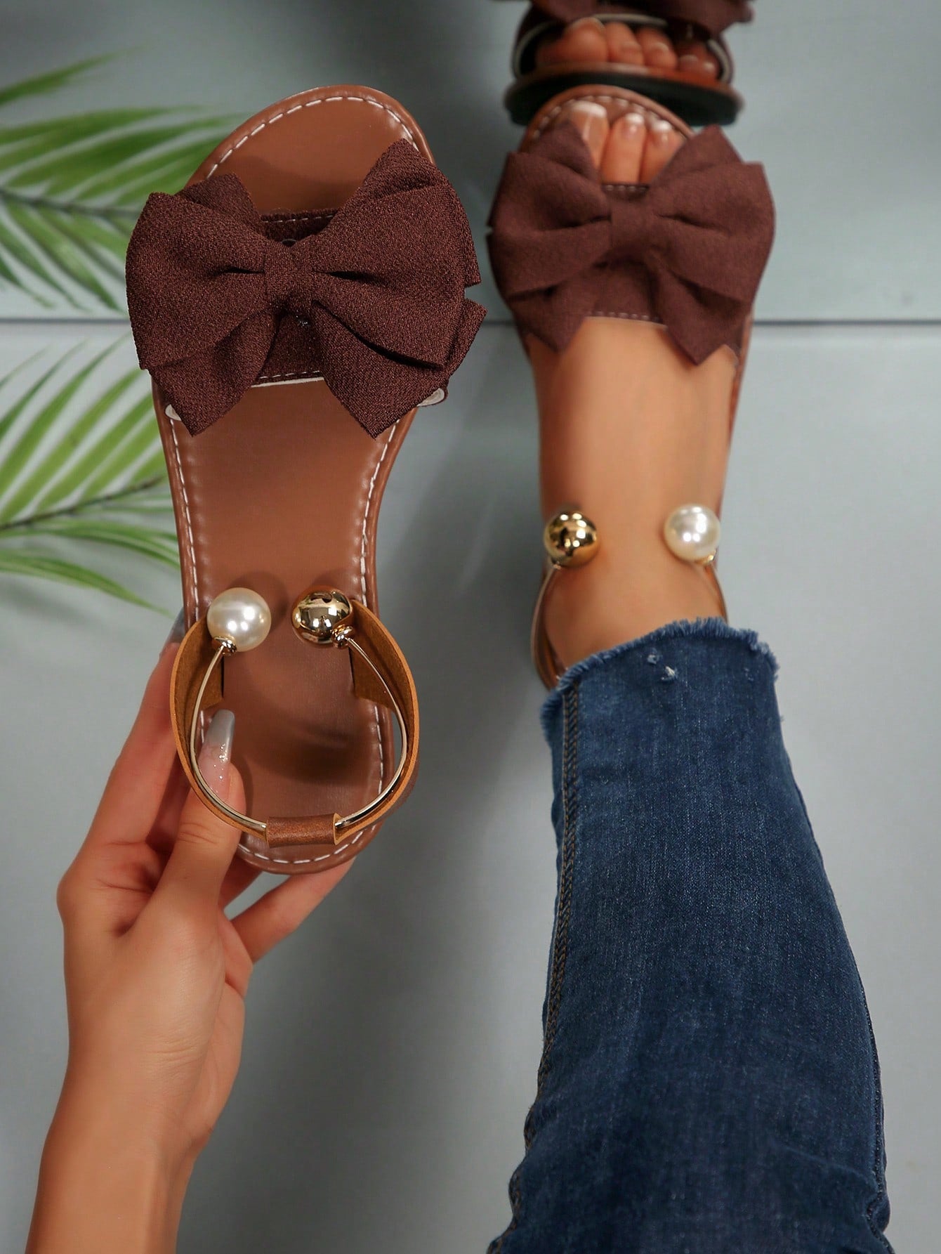 Women’s flat open-toe sandals with faux pearl decor and ankle strap design, featuring a microfiber leather upper and beach-ready fashion style.