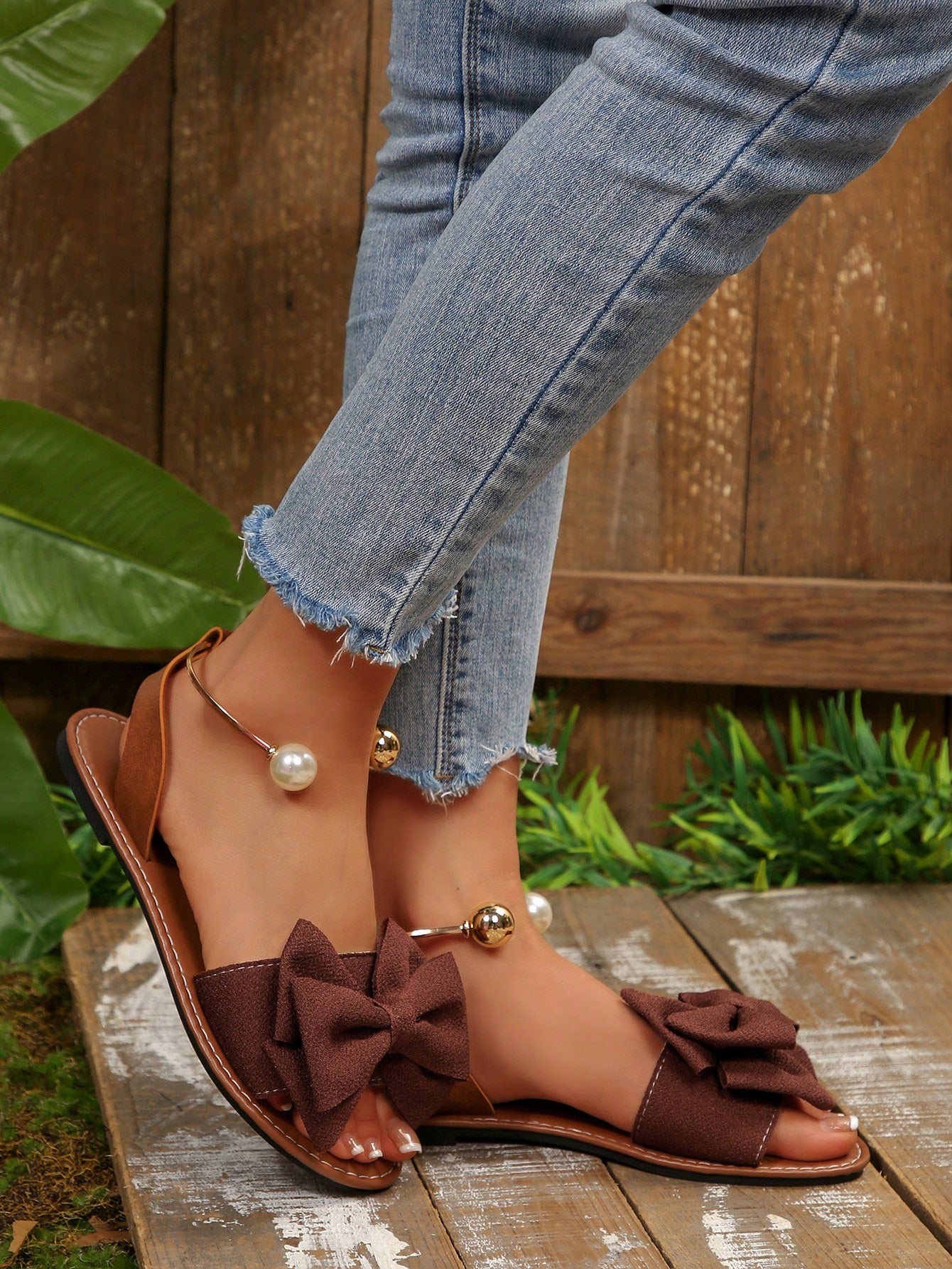 Women’s flat open-toe sandals with faux pearl decor and ankle strap design, featuring a microfiber leather upper and beach-ready fashion style.