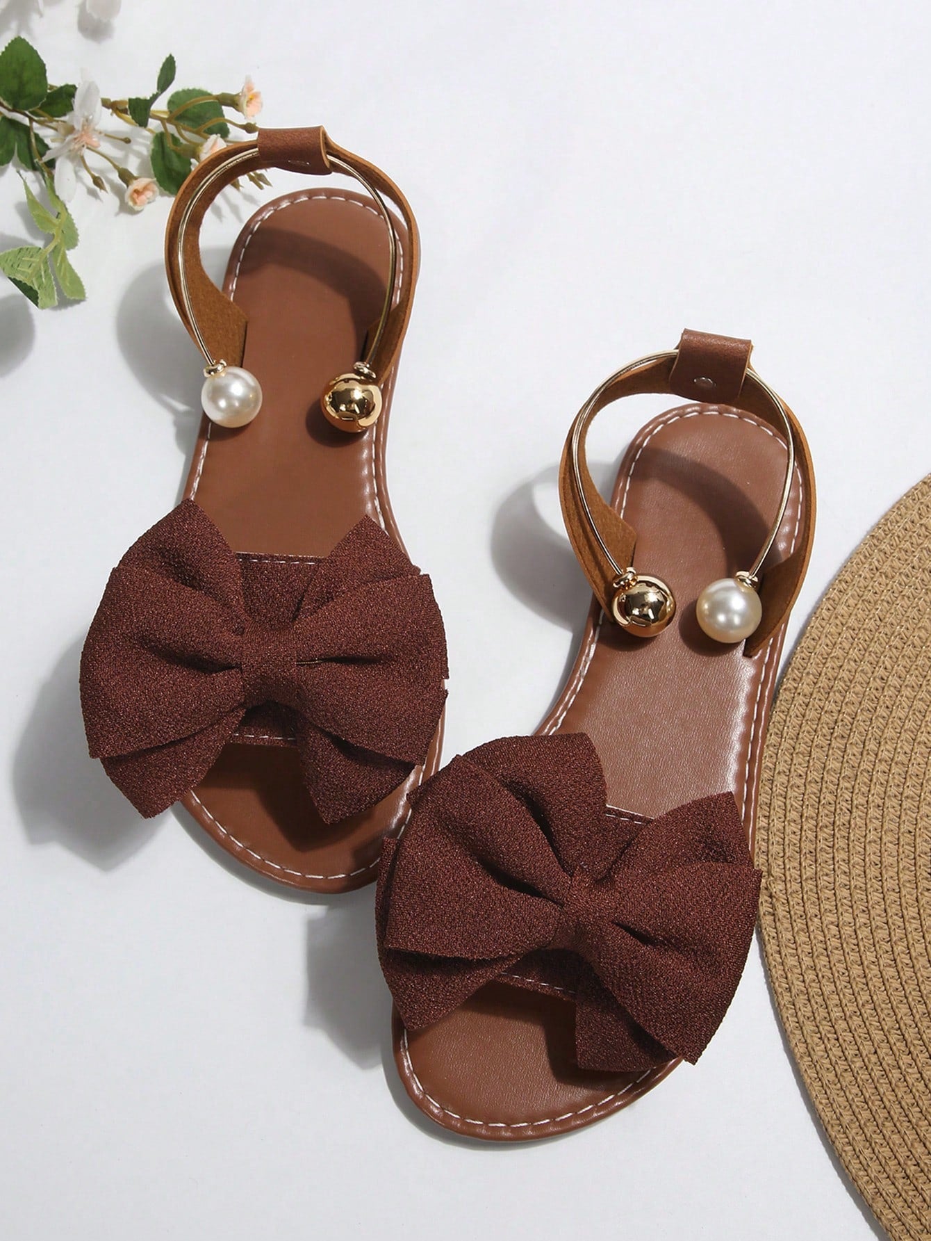 Women’s flat open-toe sandals with faux pearl decor and ankle strap design, featuring a microfiber leather upper and beach-ready fashion style.