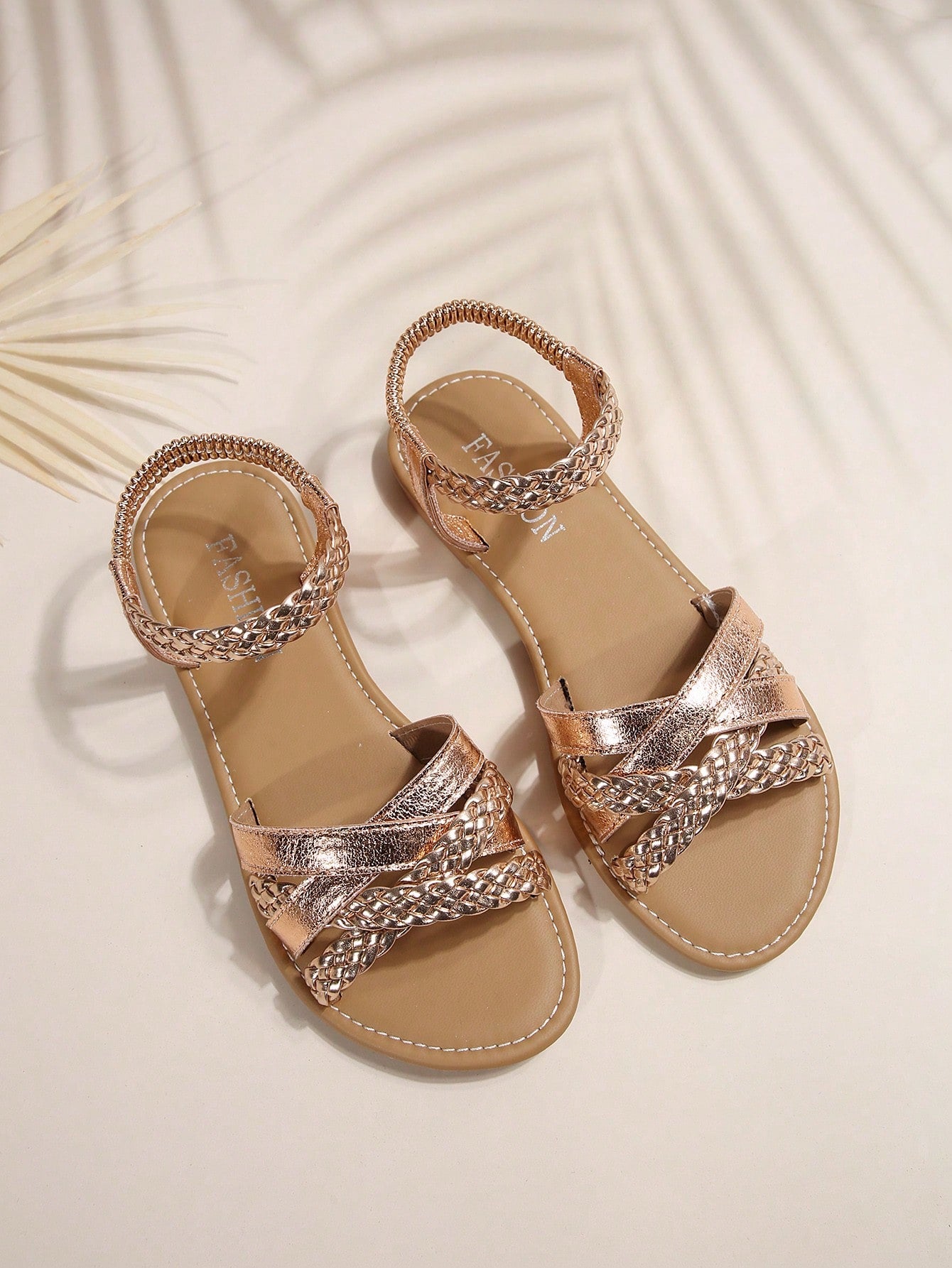 Women’s flat slide sandals with criss-cross straps, open toe, and braid detail, designed for lightweight casual and beach wear.