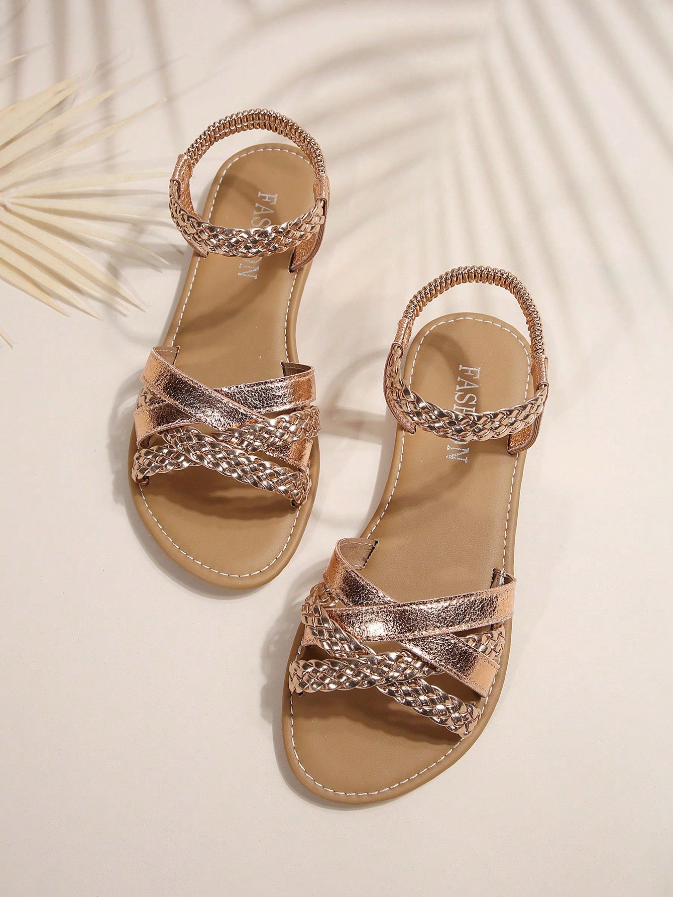 Women’s flat slide sandals with criss-cross straps, open toe, and braid detail, designed for lightweight casual and beach wear.