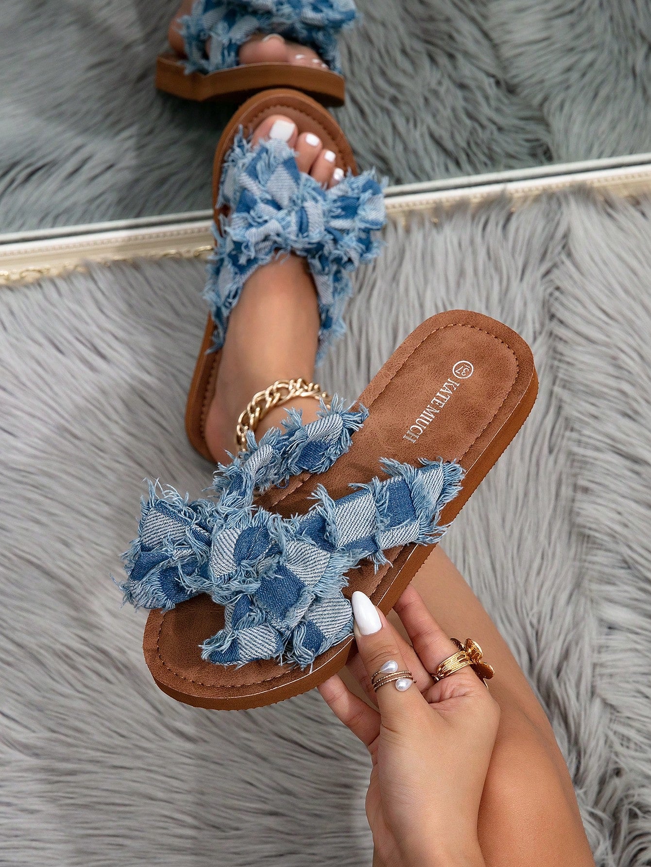 Women's flat slide sandals with ruched fabric, bow accent, and fringe detail, suitable for outdoor vacation wear.