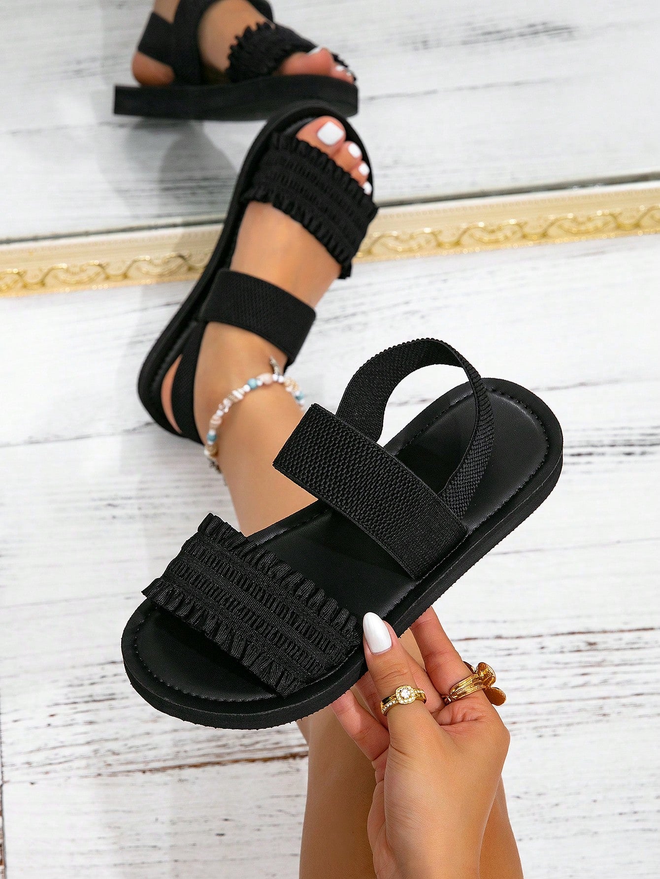 Women's flat slide sandals with ruched fabric, bow accent, and fringe detail, suitable for outdoor vacation wear.