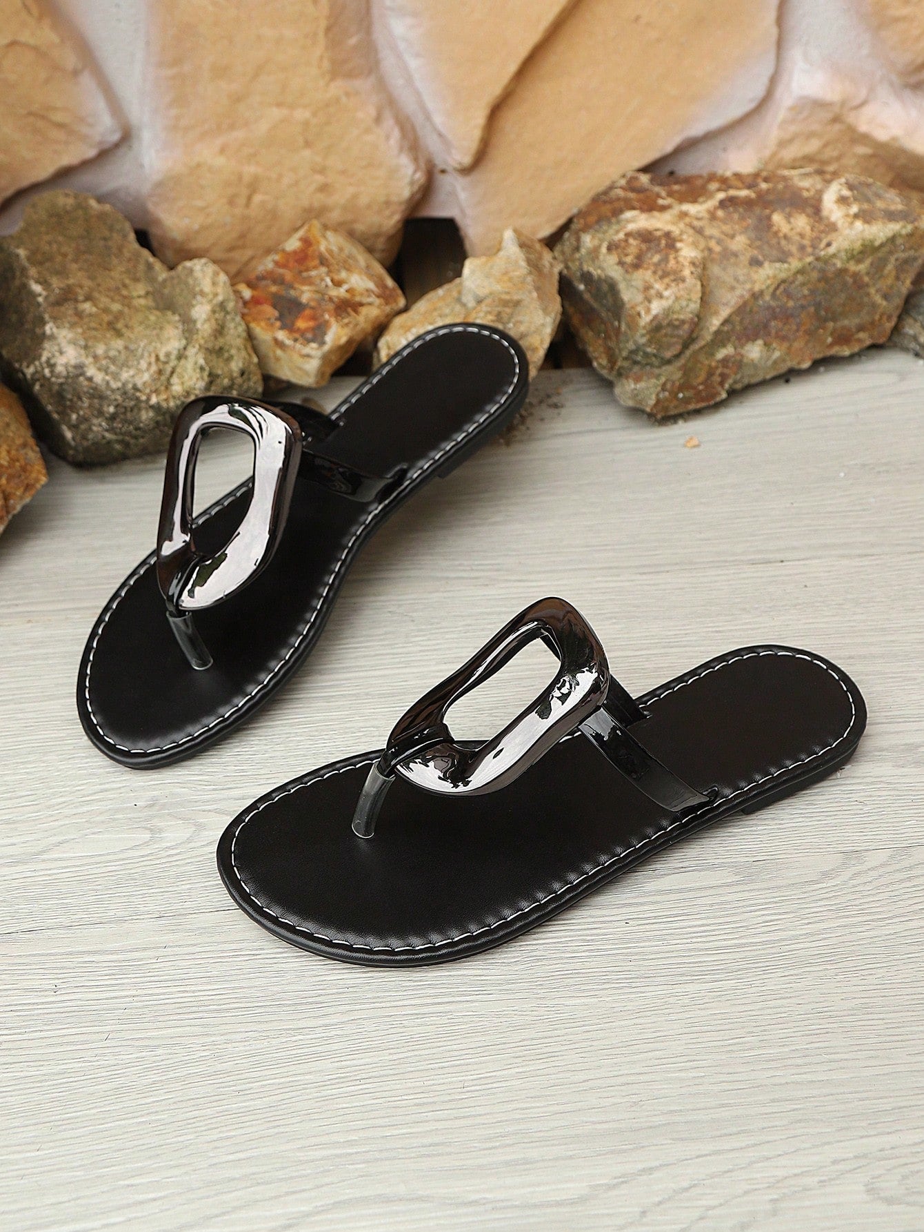 Women’s gold flat slide sandals with open toe post design and metal buckle detail, shown as fashionable outdoor summer footwear.