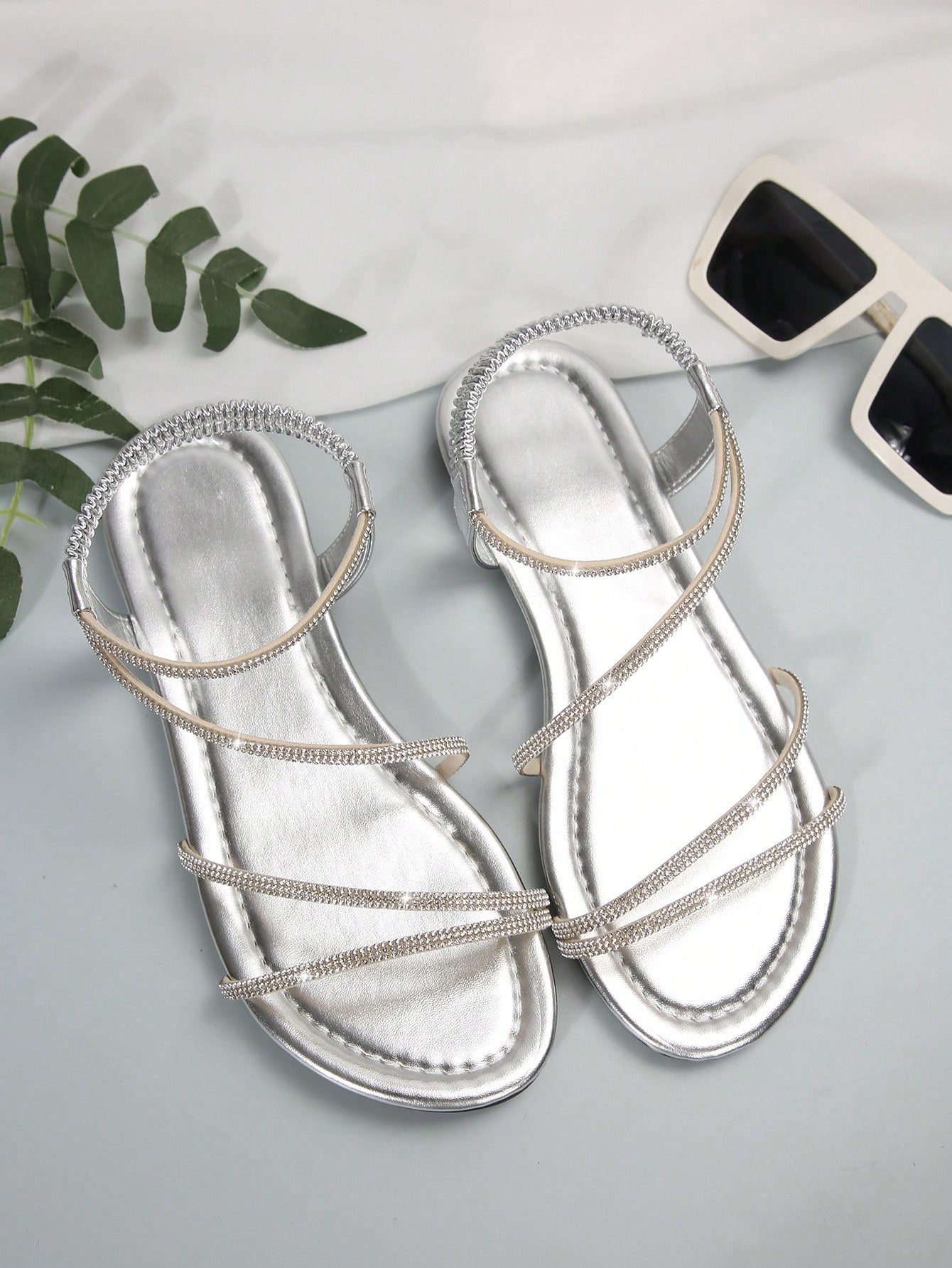 Women's flat sandals with rhinestone strap detail, elastic back, and open round toe in slide style for outdoor or beach wear.