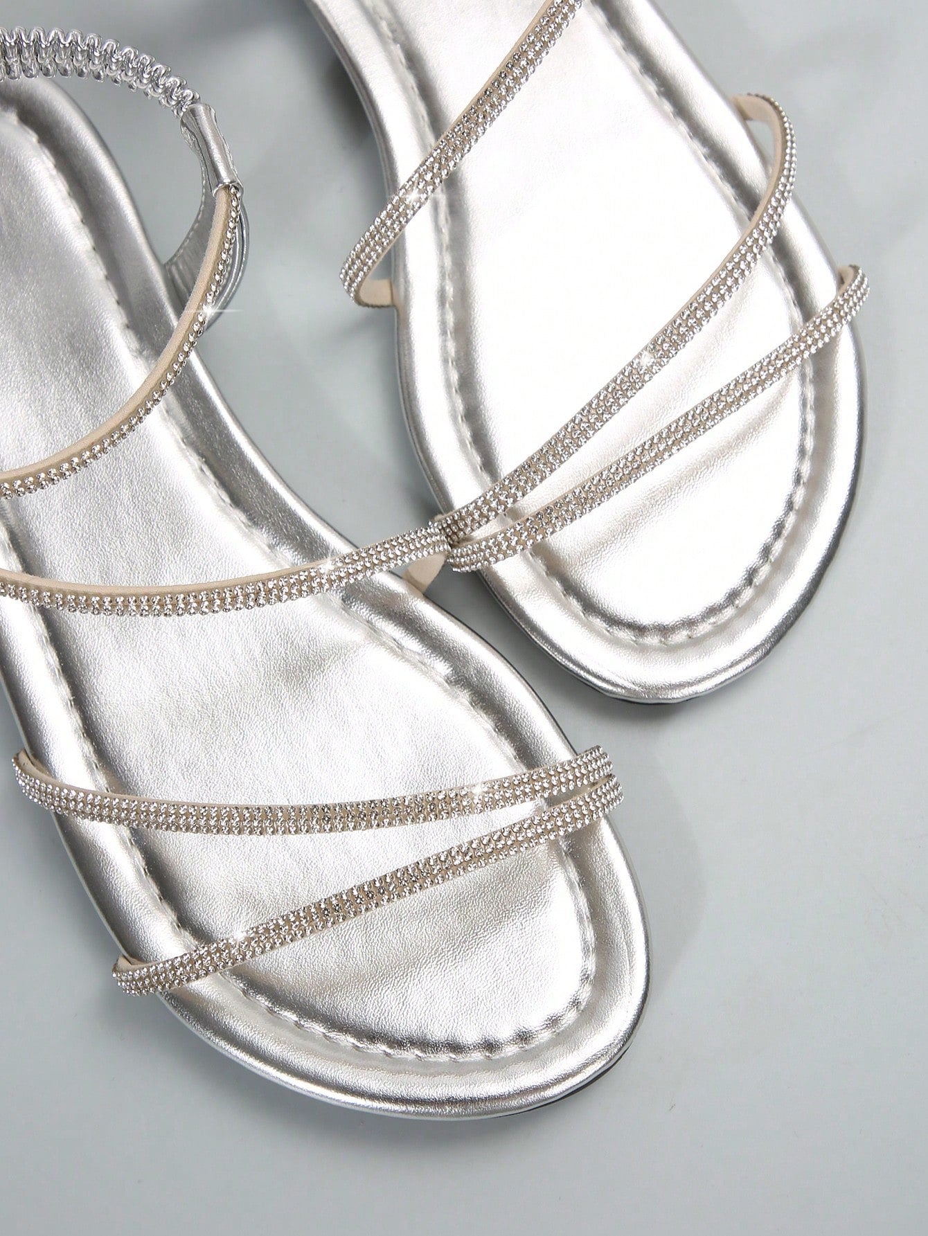 Women's flat sandals with rhinestone strap detail, elastic back, and open round toe in slide style for outdoor or beach wear.