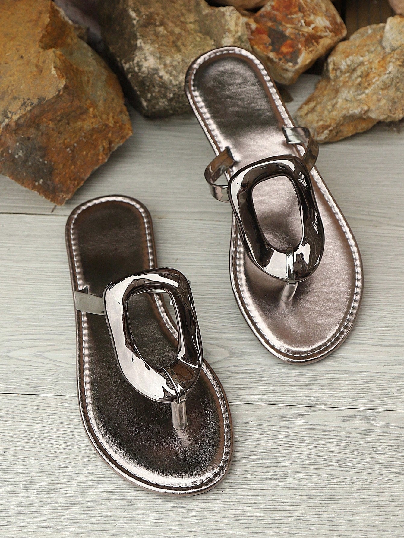 Women’s gold flat slide sandals with open toe post design and metal buckle detail, shown as fashionable outdoor summer footwear.