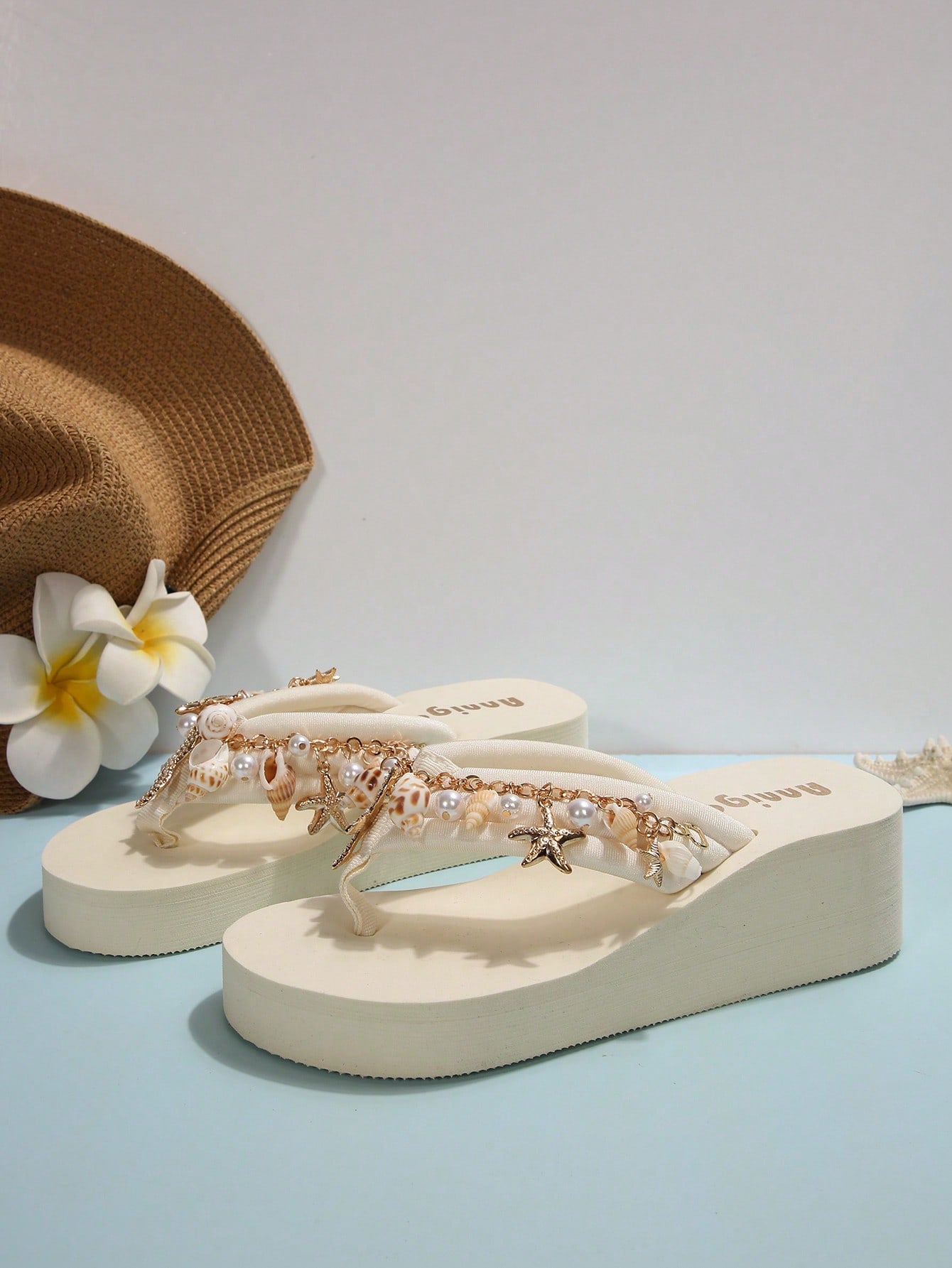Beige women’s platform wedge slip-on sandals with toe post, shell chain decor, and flower rhinestone details, designed in a beach holiday flip-flop style.