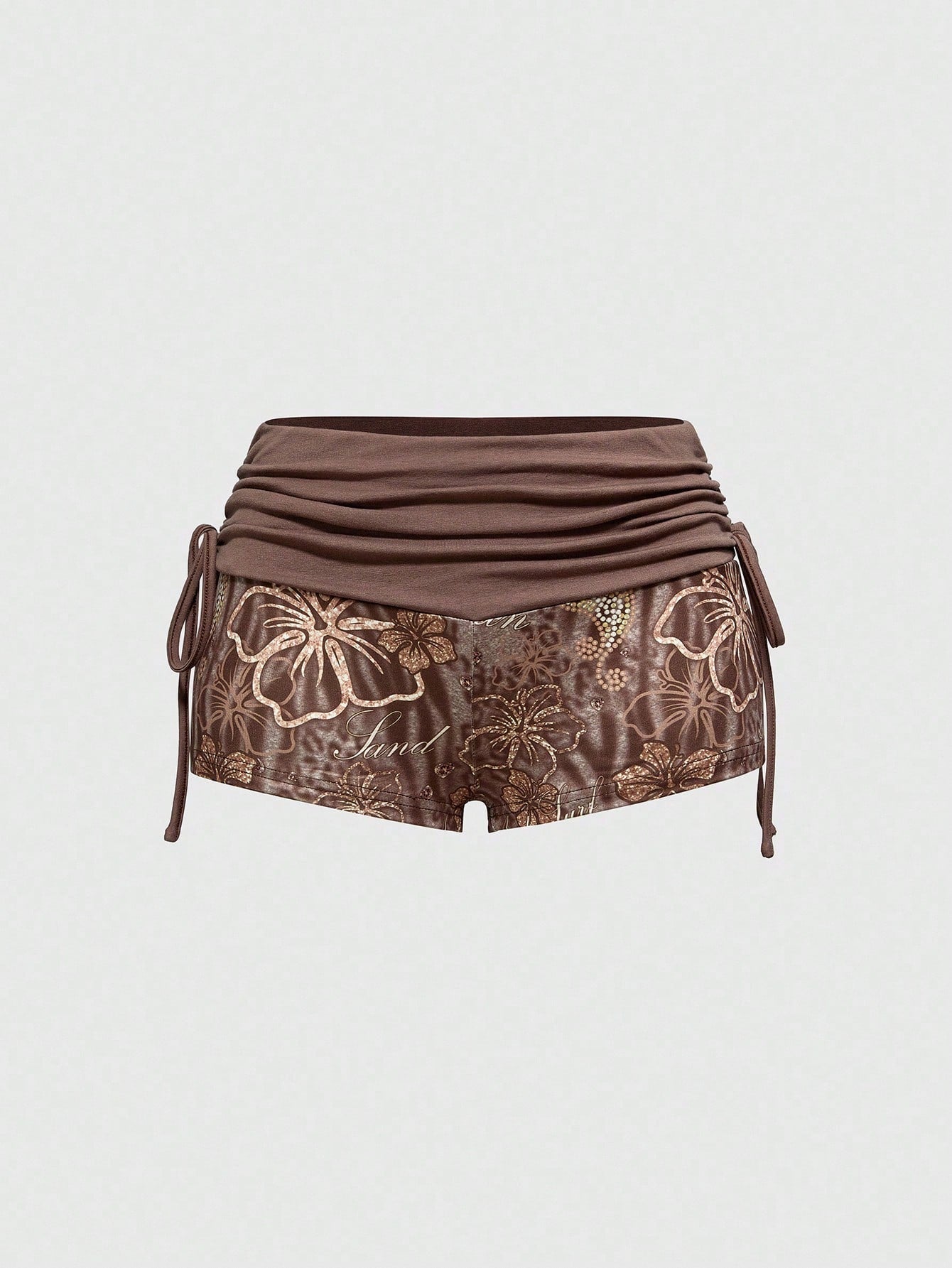 Women's low waist mini track shorts with elastic waistband, drawstring knot, ruched details, and plant pattern in a Y2K boho style