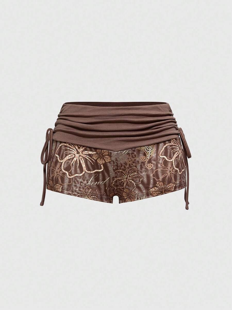 Women's low waist mini track shorts with elastic waistband, drawstring knot, ruched details, and plant pattern in a Y2K boho style