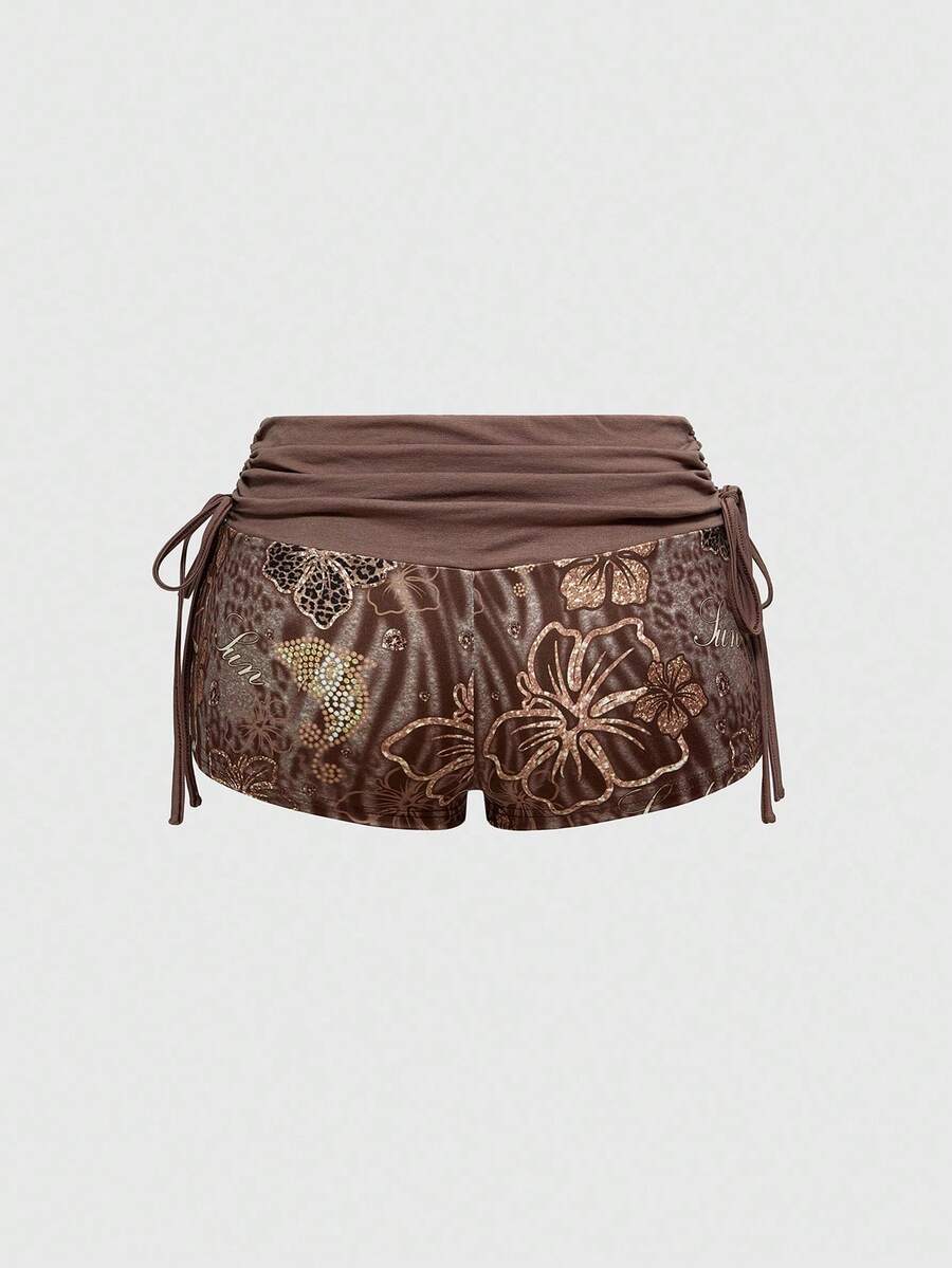 Women's low waist mini track shorts with elastic waistband, drawstring knot, ruched details, and plant pattern in a Y2K boho style