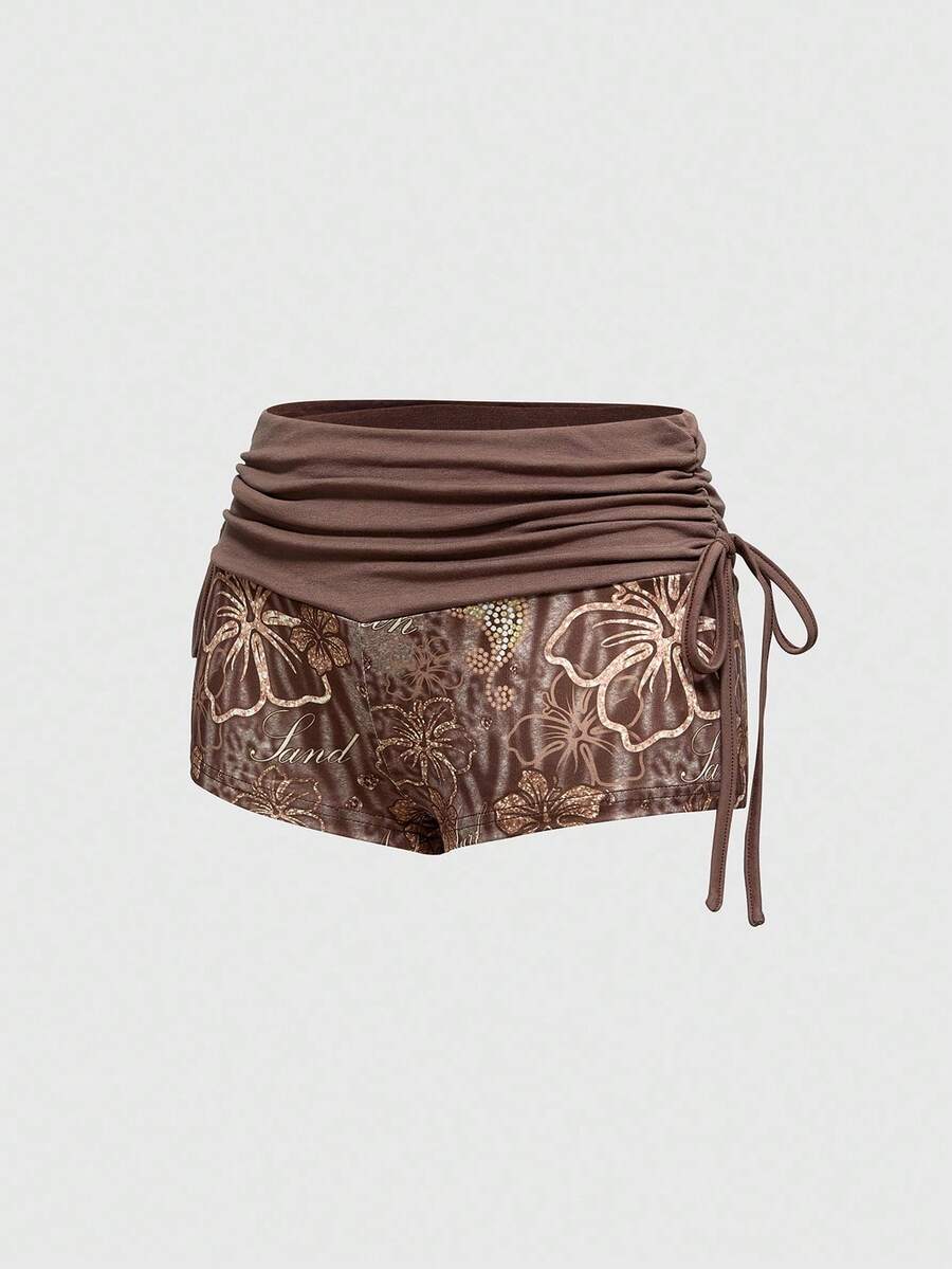 Women's low waist mini track shorts with elastic waistband, drawstring knot, ruched details, and plant pattern in a Y2K boho style