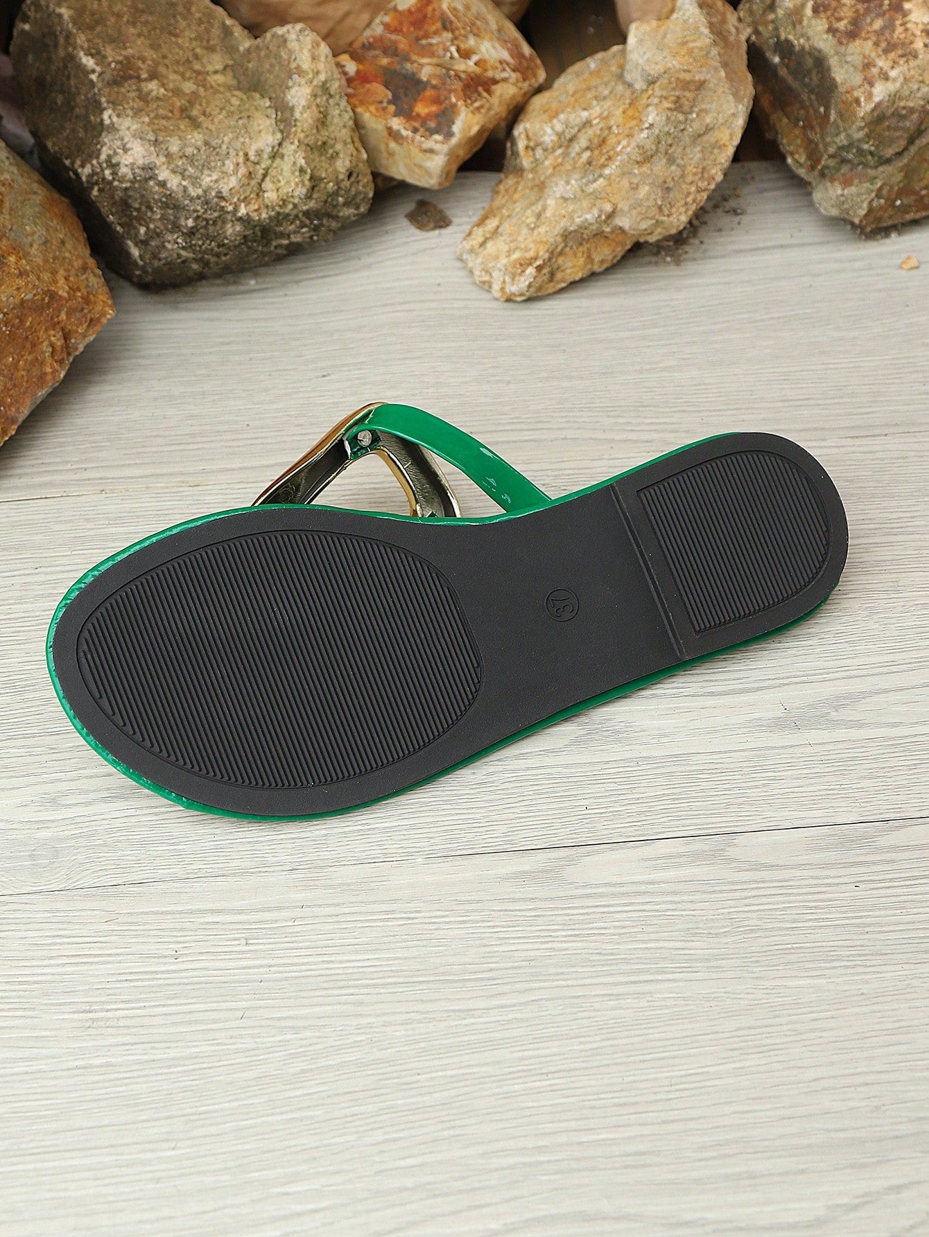 Women’s gold flat slide sandals with open toe post design and metal buckle detail, shown as fashionable outdoor summer footwear.