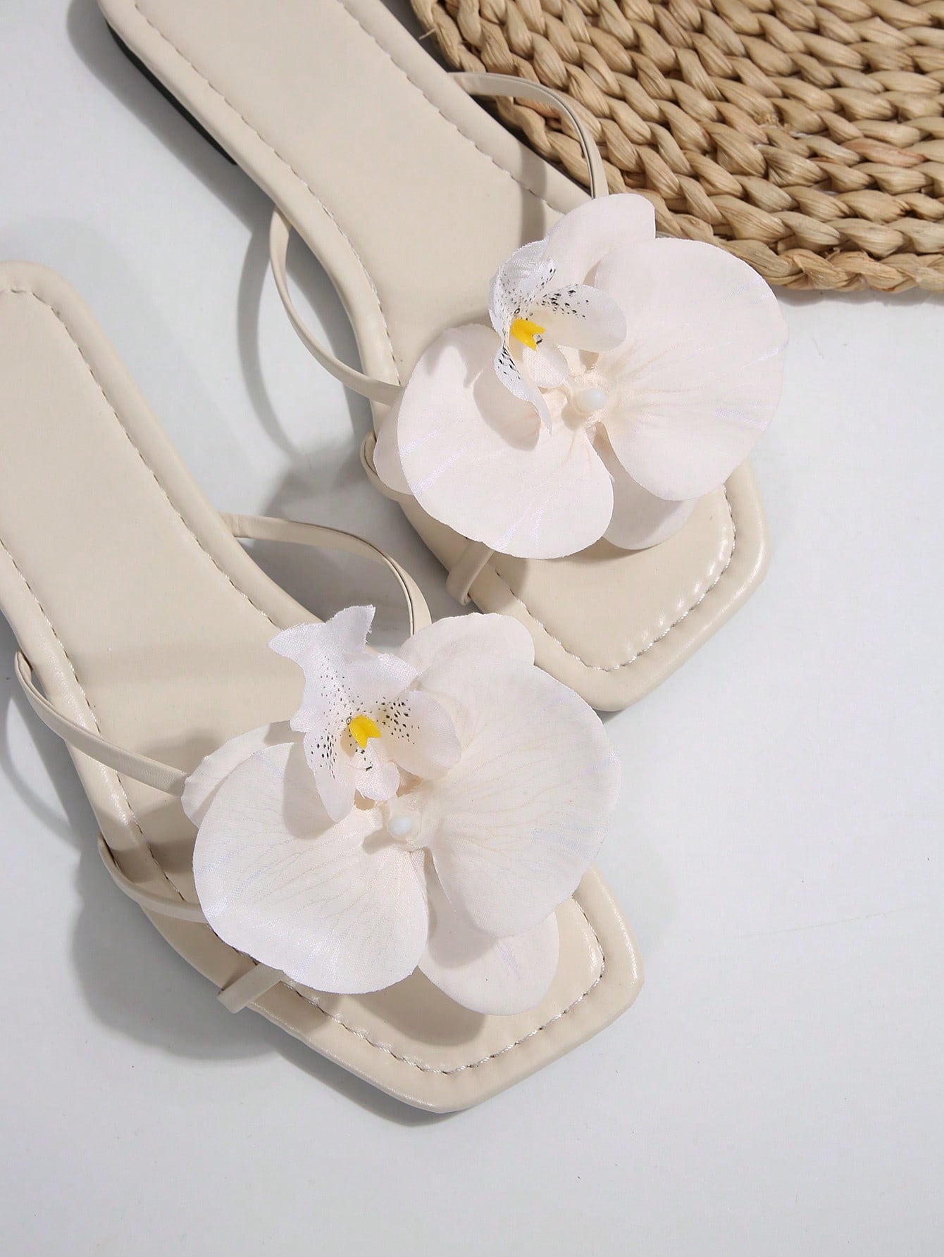 Wide fit women's beige flat thong sandals with butterfly orchid appliqué decor and open toe, suitable for beach, vacation, home, and casual everyday wear.